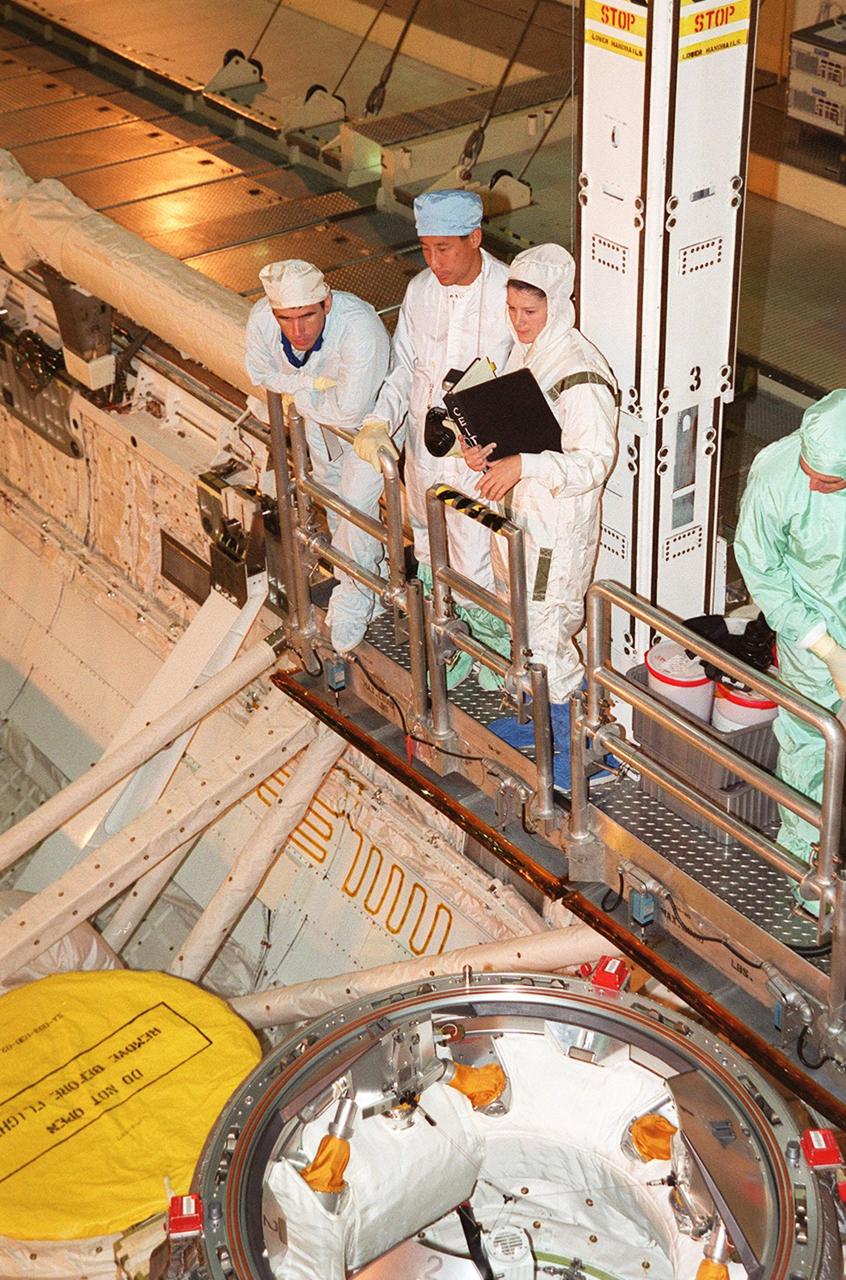 In Orbiter Processing Facility bay 3, STS-106 Mission Specialists Yuri I. Malenchenko (left) and Edward T. Lu (beside him) familiarize themselves with equipment in the payload bay of Space Shuttle orbiter Atlantis with the help of KSC employees as part of Crew Equipment Interface Test (CEIT) activities for their mission. The other crew members are Commander Terrence W. Wilcutt, Pilot Scott D. Altman, and Mission Specialists Daniel C. Burbank, Boris V. Morukov and Richard A. Mastracchio. Malenchenko and Morukov represent the Russian Aviation and Space Agency. On the 11-day mission, the seven-member crew will perform support tasks on orbit, transfer supplies and prepare the living quarters in the newly arrived Zvezda Service Module for the first long-duration crew, dubbed "Expedition One," which is due to arrive at the Station in late fall. STS-106 is scheduled to launch Sept. 8, 2000, at 8:31 a.m. EDT from Launch Pad 39B