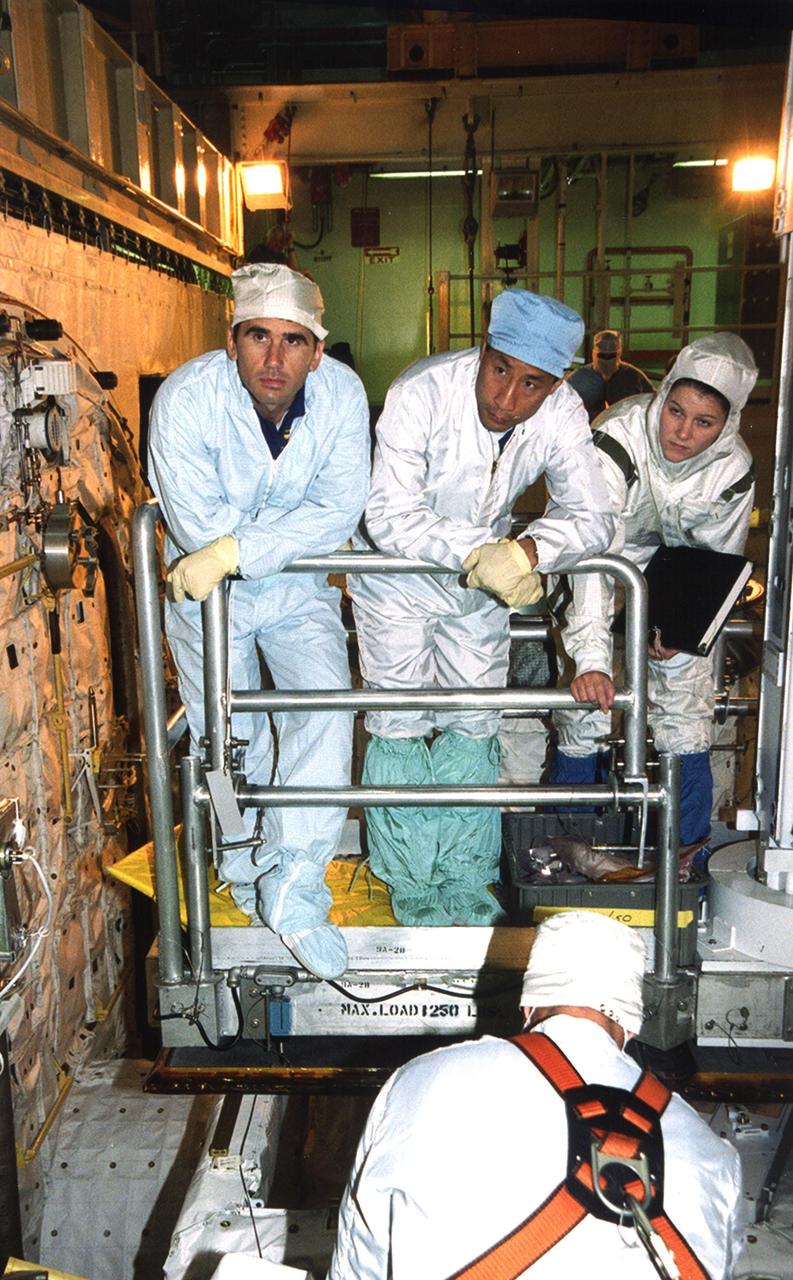 In Orbiter Processing Facility bay 3, STS-106 Mission Specialists Yuri I. Malenchenko (left) and Edward T. Lu (center) familiarize themselves with equipment in the payload bay of Space Shuttle orbiter Atlantis with the help of KSC employees as part of Crew Equipment Interface Test (CEIT) activities for their mission. The other crew members are Commander Terrence W. Wilcutt, Pilot Scott D. Altman, and Mission Specialists Daniel C. Burbank, Boris V. Morukov and Richard A. Mastracchio. Malenchenko and Morukov represent the Russian Aviation and Space Agency. On the 11-day mission, the seven-member crew will perform support tasks on orbit, transfer supplies and prepare the living quarters in the newly arrived Zvezda Service Module for the first long-duration crew, dubbed "Expedition One," which is due to arrive at the Station in late fall. STS-106 is scheduled to launch Sept. 8, 2000, at 8:31 a.m. EDT from Launch Pad 39B