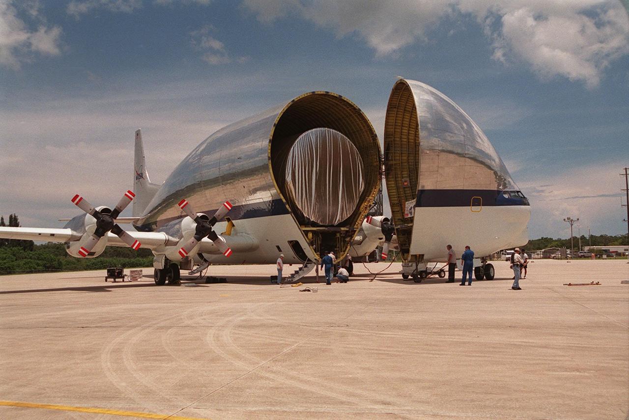 On July 26, 2000 the P-1 truss arrived at Kennedy Space Center’s Shuttle Landing Facility aboard its &quot;Super Guppy&quot; transport. The transport’s cargo bay was opened showing the American flag and NASA logo as the P-1 truss was off loaded in preparation for movement to the Operations and Checkout Building for processing. The P-1 truss, scheduled to fly in spring of 2002, is part of a total 10-truss, girder-like structure that will ultimately extend the length of a football field. Astronauts will attach the 14-by-15 foot structure to the port side of the center truss, SO, during the spring assembly flight. The 33,000-pound P-1 will house the thermal radiator rotating joint (TRRJ) that will rotate the International Space Station’s radiators away form the sun to increase their maximum cooling efficiency