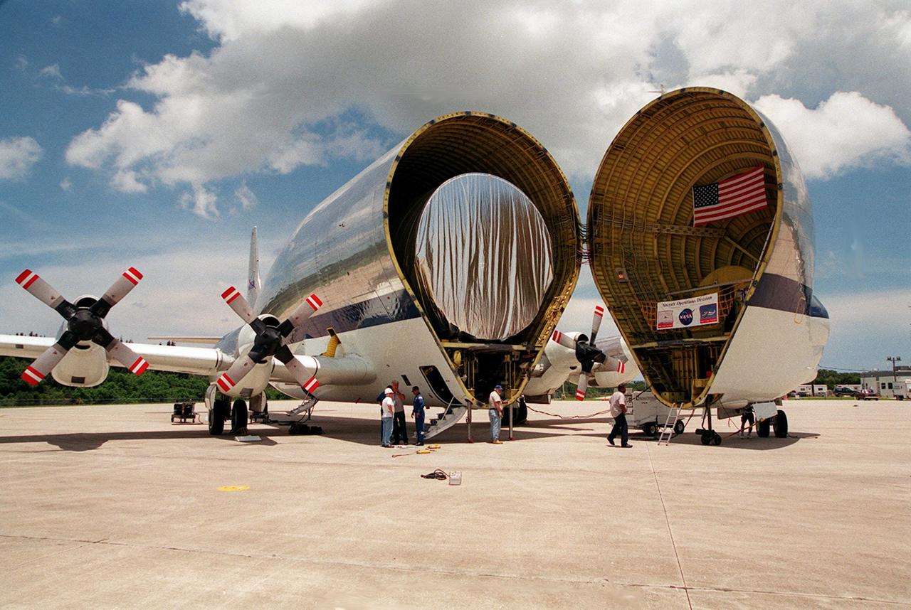 On July 26, 2000 the P-1 truss arrived at Kennedy Space Center’s Shuttle Landing Facility aboard its &quot;Super Guppy&quot; transport. The transport’s cargo bay was opened showing the American flag and NASA logo as the P-1 truss was off loaded in preparation for movement to the Operations and Checkout Building for processing. The P-1 truss, scheduled to fly in spring of 2002, is part of a total 10-truss, girder-like structure that will ultimately extend the length of a football field. Astronauts will attach the 14-by-15 foot structure to the port side of the center truss, SO, during the spring assembly flight. The 33,000-pound P-1 will house the thermal radiator rotating joint (TRRJ) that will rotate the International Space Station’s radiators away from the sun to increase their maximum cooling efficiency
