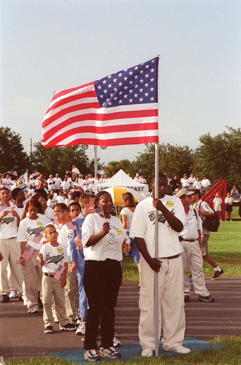 Children representing the Brevard Police Athletic League carry the U.S. Flag as they march in a parade at the KSC Visitor Complex during opening ceremonies of the 2000 International Law Enforcement Games. More than 1,850 participants and their families took part in the opening, held in the Rocket Garden. The ceremony included parades, torch lighting and a tug of war. The games feature officers from 15 countries and 37 United States in competitions around Brevard County, Fla