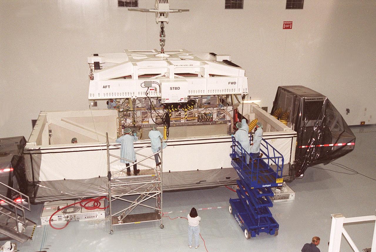 KENNEDY SPACE CENTER, FLA. -- In the Space Station Processing Facility, workers oversee the removal of the P4 truss from the truck that transported it from Tulsa, Okla. Part of the 10-truss, girder-like structure that will ultimately extend the length of a football field on the International Space Station, the P4 is the second port truss segment that will attach to the first port truss segment (P1 truss). The P4 is scheduled for mission 12A in September 2002.