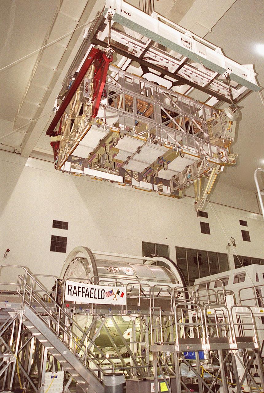 KENNEDY SPACE CENTER, FLA. -- Suspended by an overhead crane in the Space Station Processing Facility, the International Space Station’s P4 truss moves toward a workstand. Below and behind it on the floor is the Multi-Purpose Logistics Module Raffaello, another segment of the Space Station. Part of the 10-truss, girder-like structure that will ultimately extend the length of a football field, the P4 is the second port truss segment that will attach to the first port truss segment (P1 truss). The P4 is scheduled for mission 12A in September 2002.