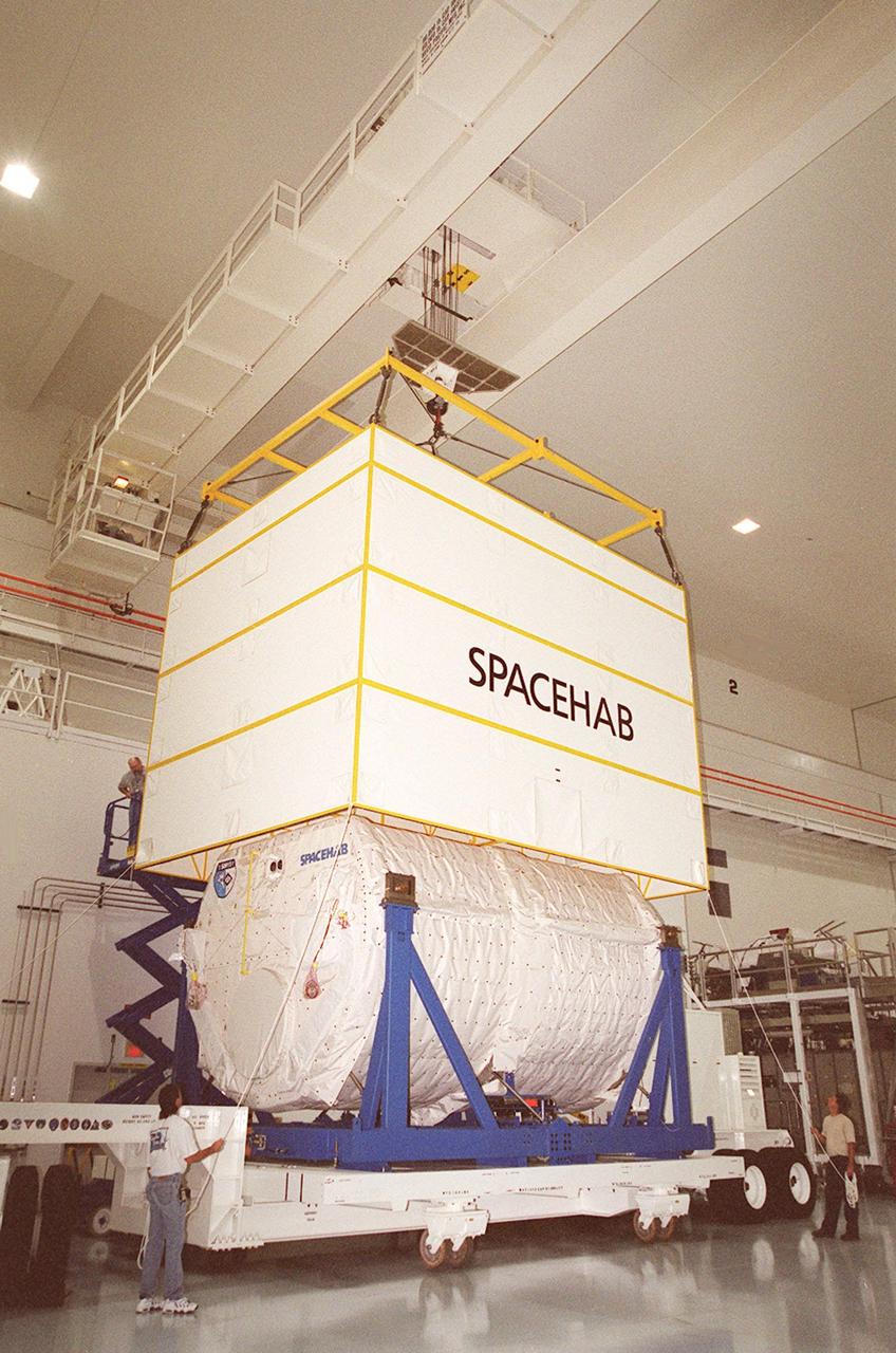 KENNEDY SPACE CENTER, FLA. --  In the Space Station Processing Facility, an overhead crane lifts the cover off of the SPACEHAB module, which rests on a transport vehicle. The module, part of the payload on mission STS-106, will be placed in the payload canister for transport to the launch pad. STS-106 is scheduled to launch Sept. 8 at 8:31 a.m. EDT