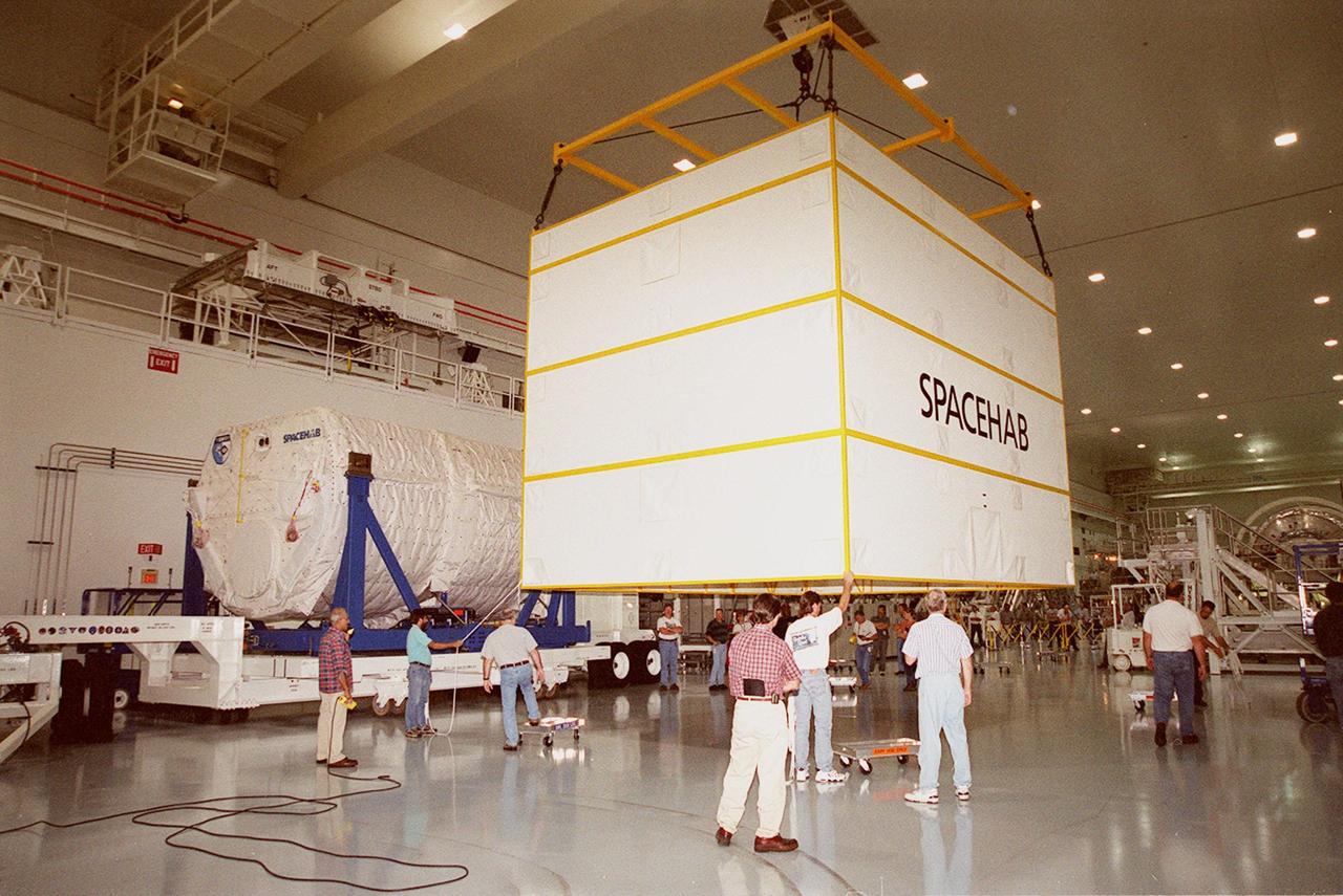 KENNEDY SPACE CENTER, FLA. --  In the Space Station Processing Facility, an overhead crane lowers the cover from the SPACEHAB module (at left) onto the floor. The module, part of the payload on mission STS-106, will be placed in the payload canister for transport to the launch pad. STS-106 is scheduled to launch Sept. 8 at 8:31 a.m. EDT