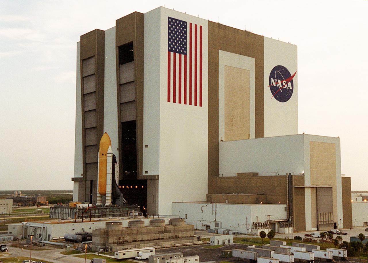 KENNEDY SPACE CENTER, FLA. -- Just after sunup, Shuttle Atlantis sits outside the Vehicle Assembly Building's (VAB) high bay 2 on the building's west side after completing a fit check.  This is the first time in Space Shuttle history that a fully stacked Shuttle is being moved into the space. The VAB and nearby rock-paved crawlerway have recently undergone major modifications to provide Shuttle fliglht hardware more storage space and protection - "Safe Haven" - from hurricanes or tropical storms.  Atlantis, the twin solid rocket boosters and external tank begain moving out of VAB high bay 1 on the east side at 2:59 a.m. EDT.  The 6-million pound crawler transporter carried the Mobile Launcher Platform and Space Shuttle around the north side of the VAB and into high bay 2.  After the successful "Safe Haven" fit check, Shuttle Atlantis is scheduled to roll out to Launch Pad 39B in preparation for the STS-106 launch on Sept. 8.