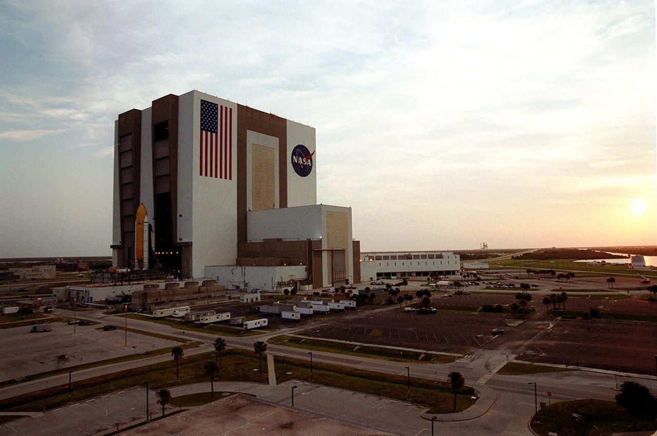 KENNEDY SPACE CENTER, FLA. -- The sun is rising over the Atlantic Ocean (right) as Shuttle Atlantis sits outside the Vehicle Assembly Building's (VAB) high bay 2 on the building's west side after completing a fit check.  This is the first time in Space Shuttle history that a fully stacked Shuttle has been moved into the space. The VAB and nearby rock-paved crawlerway have recently undergone major modifications to provide Shuttle fliglht hardware more storage space and protection - "Safe Haven" - from hurricanes or tropical storms.  Atlantis, the twin solid rocket boosters and external tank begain moving out of VAB high bay 1 on the east side at 2:59 a.m. EDT.  The 6-million pound crawler transporter carried the Mobile Launcher Platform and Space Shuttle around the north side of the VAB and into high bay 2.  After the successful "Safe Haven" fit check, Shuttle Atlantis is scheduled to roll out to Launch Pad 39B in preparation for the STS-106 launch on Sept. 8.