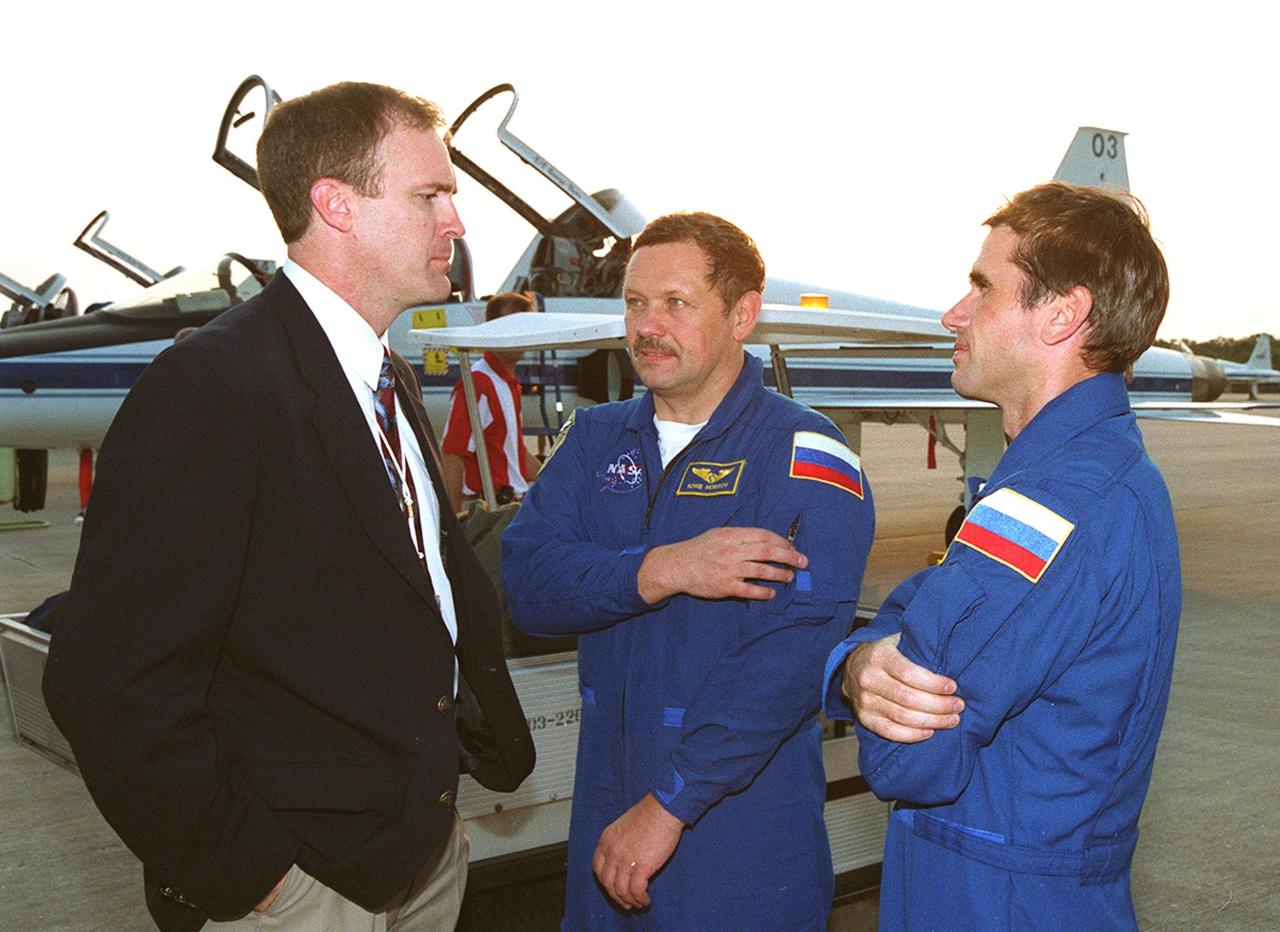Jim Halsell Jr. (left), former mission commander and now the manager, Shuttle Program Integration Office, chats with STS-106 Mission Specialists Boris V. Morukov (center) and Yuri I. Malenchenko (right) after their arrival at KSC. Morukov and Malenchenko, who are with the Russian Aviation and Space Agency, are at KSC with the rest of the crew to take part in Terminal Countdown Demonstration Test activities, which include emergency egress training and a simulated launch countdown. STS-106 is scheduled to launch Sept. 8, 2000, at 8:31 a.m. EDT from Launch Pad 39B. On the 11-day mission, the seven-member crew will perform support tasks on orbit, transfer supplies and prepare the living quarters in the newly arrived Zvezda Service Module. The first long-duration crew, dubbed “Expedition One,” is due to arrive at the Station in late fall