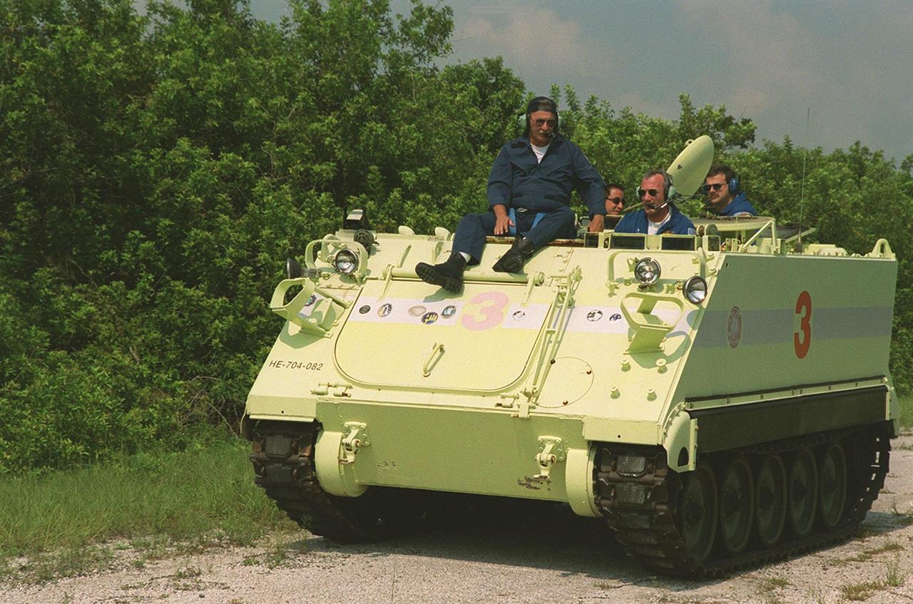 Capt. George Hoggard, trainer with the KSC Fire Department, oversees STS-106 Commander Terrence W. Wilcutt as he the practices driving the small armored personnel carrier that is part of emergency egress training. Behind Hoggard and Wilcutt are Mission Specialist Edward T. Lu and Pilot Scott D. Altman. They and the rest of the crew are taking part in Terminal Countdown Demonstration Test (TCDT) activities. The tracked vehicle could be used by the crew in the event of an emergency at the pad during which the crew must make a quick exit from the area. The TCDT also provides simulated countdown exercises and opportunities to inspect the mission payloads in the orbiter’s payload bay. STS-106 is scheduled to launch Sept. 8, 2000, at 8:31 a.m. EDT from Launch Pad 39B. On the 11-day mission, the seven-member crew will perform support tasks on orbit, transfer supplies and prepare the living quarters in the newly arrived Zvezda Service Module. The first long-duration crew, dubbed “Expedition One,” is due to arrive at the Station in late fall