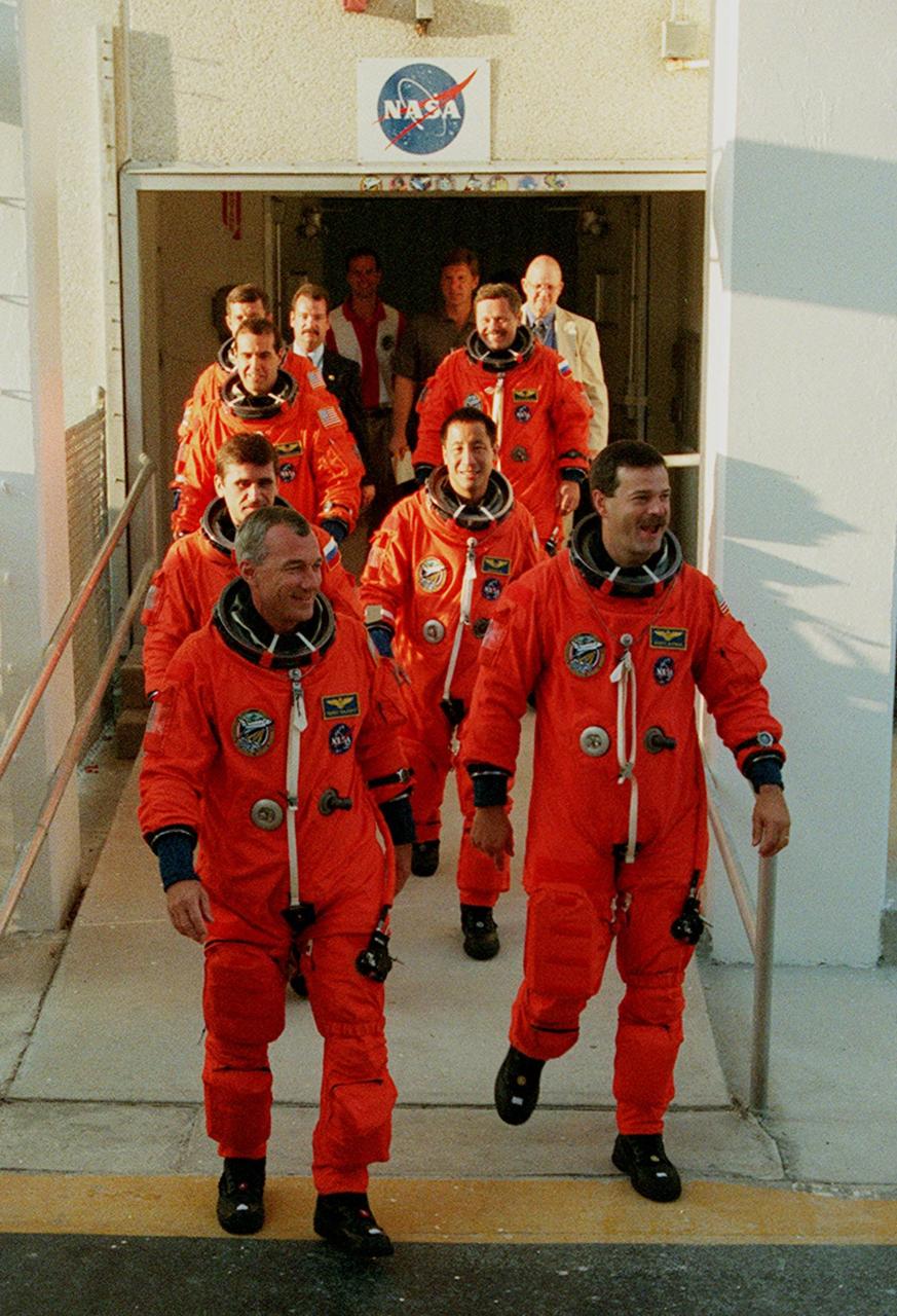 KENNEDY SPACE CENTER, Fla.  -- The STS-106 flight crew departs the Operations & Checkout Facility to take part in Terminal Countdown Demonstration Test (TCDT) activities. The TCDT provides the crew with emergency egress training and opportunities to inspect their mission payload in the orbiter’s payload bay. Crew members taking part in the TCDT are, from left to right front to back, Commander Terrence W. Wilcutt, Pilot Scott D. Altman, Mission Specialists Yuri I. Malenchenko, Edward T. Lu, Richard A. Mastracchio, Boris V. Morukov and Daniel C. Burbank. Malenchenko and Morukov are with the Russian Aviation and Space Agency. STS-106 is scheduled to launch Sept. 8, 2000, at 8:31 a.m. EDT from Launch Pad 39B. On the 11-day mission, the seven-member crew will perform support tasks on orbit, transfer supplies and prepare the living quarters in the newly arrived Zvezda Service Module. The first long-duration crew, dubbed “Expedition One,” is due to arrive at the Station in late fall