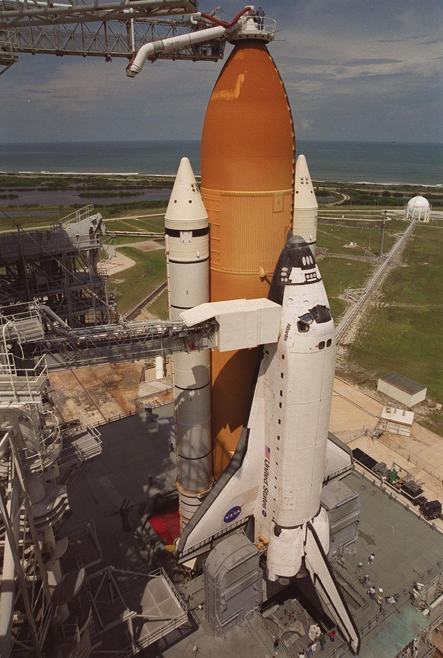 KENNEDY SPACE CENTER, Fla. -- Against a backdrop of the cloudy sky and blue-gray Atlantic Ocean, Space Shuttle Atlantis is revealed after rollback of the Rotating Service Structure. On top of the external tank is the 13-foot-wide “beanie cap,” at the end of the Gaseous Oxygen Vent Arm, designed to vent gaseous oxygen vapors away from the Space Shuttle. Lower is the Orbiter Access Arm with the environmental chamber, known as the “white room,” extended to the orbiter. The chamber provides entry for the crew into the orbiter and also serves as emergency egress up to 7 minutes 24 seconds before launch. Ready for launch of mission STS-106 at 8:45 a.m. EDT on Sept. 8, Atlantis carries supplies to prepare the Russian Zvezda living quarters on the International Space Station for the first long-duration crew. The crew will also be transferring supplies from the Russian Progress resupply ship already docked to the aft of Zvezda. The fourth U.S. launch for the Space Station, the mission is expected to last 10 days, 19 hours and 9 minutes, landing at KSC 4:59 a.m. EDT on Sept. 19