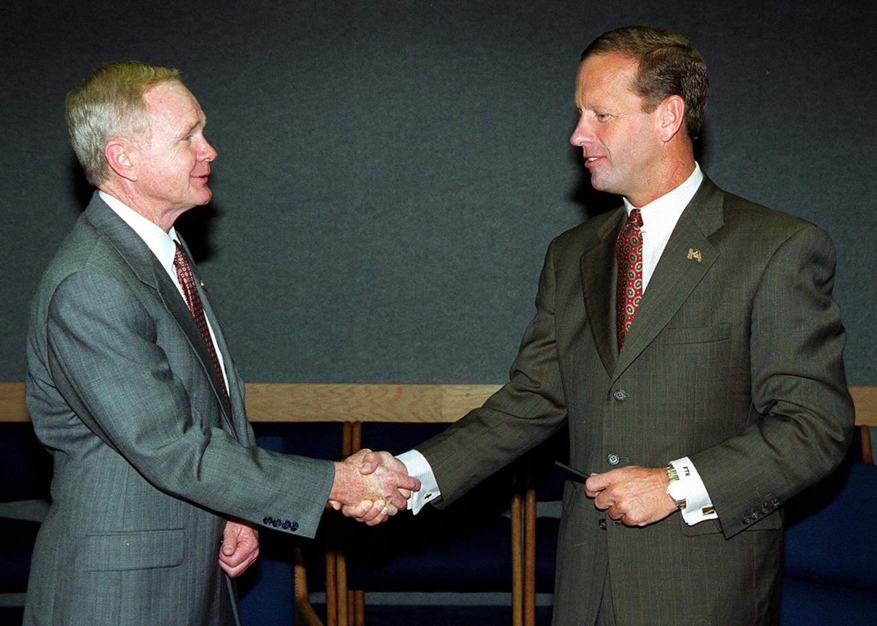 At the KSC Visitor Complex, Center Director Roy D. Bridges (left) and Florida’s Lieutenant Governor Frank T. Brogan shake hands after signing a Memorandum of Understanding (MOU). The MOU documents the intent of NASA KSC and the State of Florida to form partnerships with academic institutions in Florida for development of aerospace-related advanced training and academic/educational programs. The three-year project anticipates that the partnership and educational programs fostered will improve the lifelong learning environment for the aerospace and engineering workforce