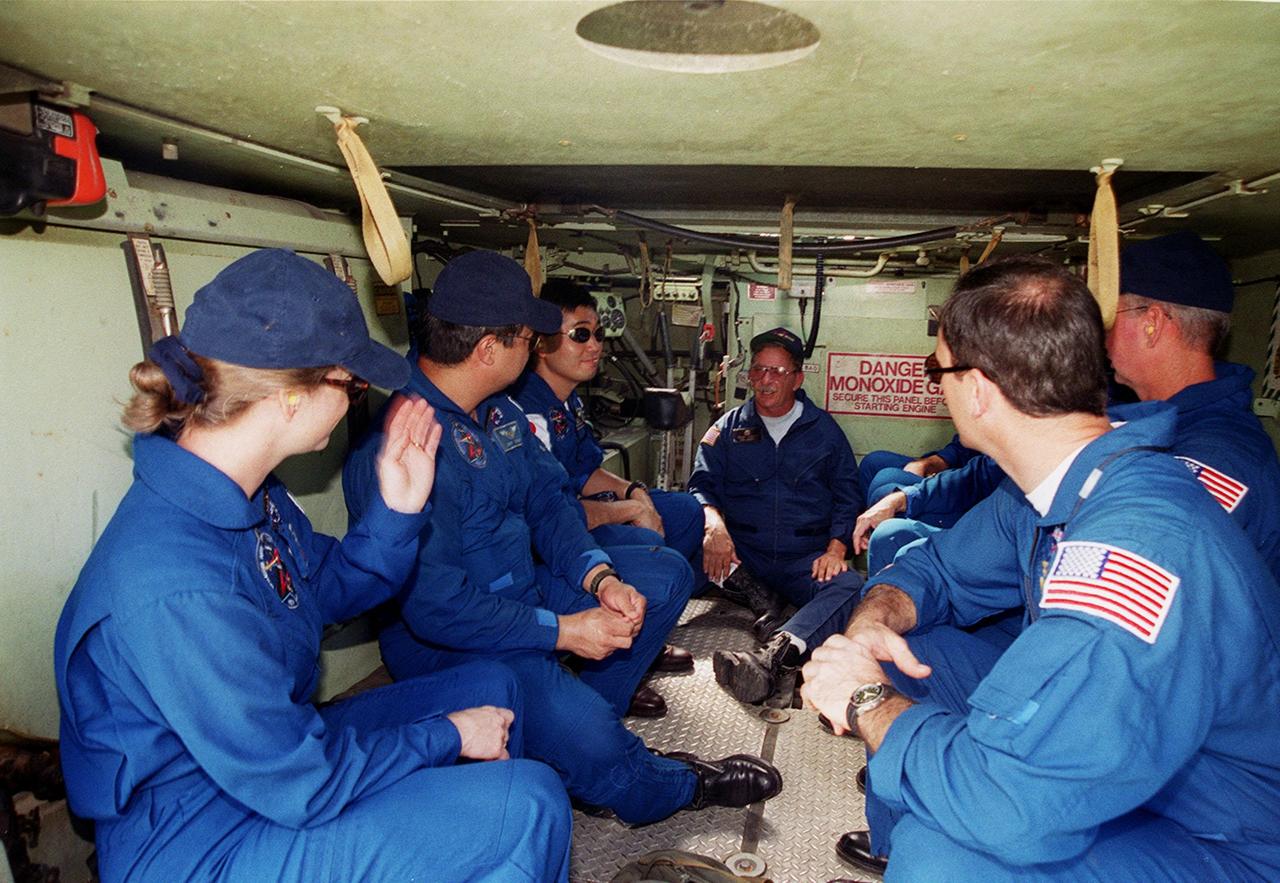 As part of emergency egress training during Terminal Countdown Demonstration Test (TCDT) activities, members of the STS-92 crew get instructions about the M-113 they are seated in at Launch Pad 39A. Seen on the left are Pilot Pam Melroy and Mission Specialists Leroy Chaio and Koichi Wakata of Japan In the middle, giving the instructions, is Capt. George Hoggard, trainer with the KSC Fire Department. At right are Commander Brian Duffy (leaning back) and Mission Specialist Michael Lopez-Alegria. The other crew members (not seen) are Mission Specialists Jeff Wisoff and Bill McArthur. The tracked vehicle could be used by the crew in the event of an emergency at the pad during which the crew must make a quick exit from the area. The TCDT also provides simulated countdown exercises and opportunities to inspect the mission payloads in the orbiter’s payload bay. STS-92 is scheduled to launch Oct. 5 at 9:30 p.m. EDT on the fifth flight to the International Space Station. It will carry two elements of the Space Station, the Integrated Truss Structure Z1 and the third Pressurized Mating Adapter. The mission is also the 100th flight in the Shuttle program