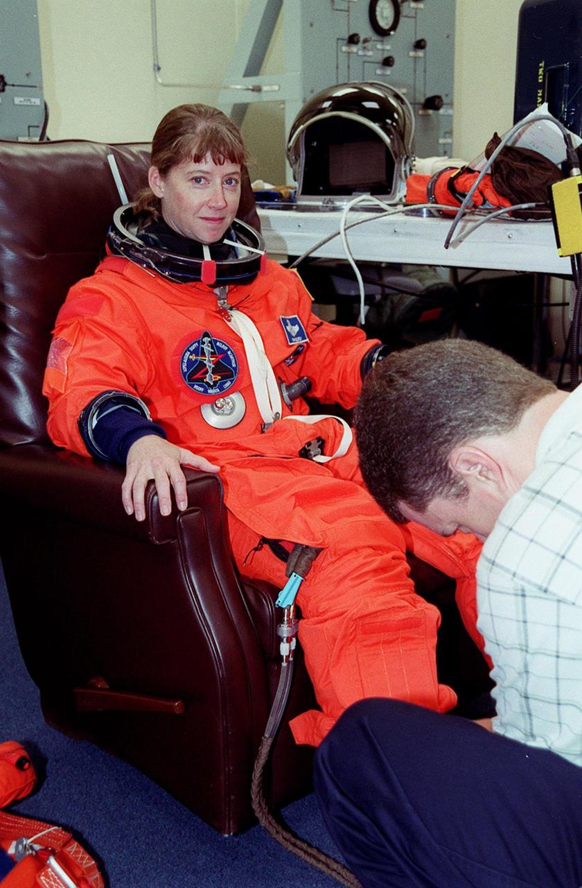 In the Operations and Checkout Building, STS-92 Pilot Pamela Ann Melroy has her new launch and entry suit adjusted during fit check. Melroy and the rest of the crew are at KSC for Terminal Countdown Demonstration Test activities. The TCDT provides emergency egress training, simulated countdown exercises and opportunities to inspect the mission payload. This mission will be Melroy’s first Shuttle flight. STS-92 is scheduled to launch Oct. 5 at 9:38 p.m. EDT from Launch Pad 39A on the fifth flight to the International Space Station. It will carry two elements of the Space Station, the Integrated Truss Structure Z1 and the third Pressurized Mating Adapter. The mission is also the 100th flight in the Shuttle program