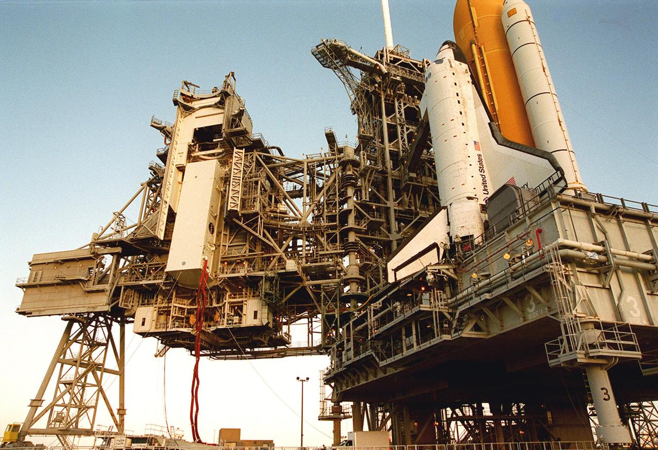 KENNEDY SPACE CENTER, Fla. --  With its umbilical hoses stretched out, the payload canister (left) with the Integrated Truss Structure Z1 inside nears the top of the passage to the Payload Changeout Room. There the Z1 truss will be removed and later transferred to Space Shuttle Discovery’s payload bay. The Z1 truss is the first of 10 that will become the backbone of the International Space Station, eventually stretching the length of a football field. Along with its companion payload, the third Pressurized Mating Adapter, the Z1 is scheduled to be launched aboard Discovery Oct. 5 at 9:38 p.m. EDT