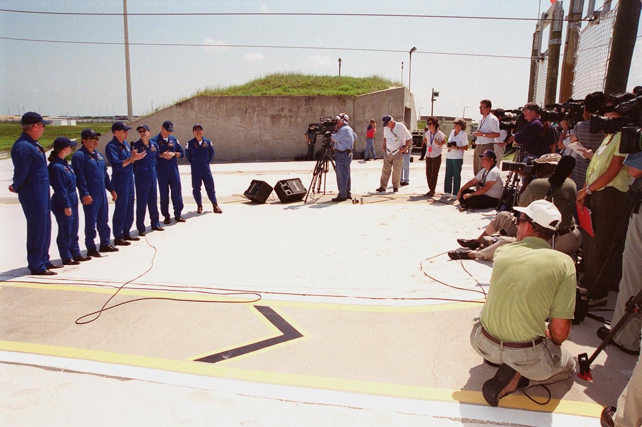 KENNEDY SPACE CENTER, FLA. -- Media (right) are gathered at the slidewire basket area of Launch Pad 39A to record the STS-92 crew, at left, during a question and answer session. The crew members are (left to right) Commander Brian Duffy, Pilot Pamela Ann Melroy and Mission Specialists Leroy Chiao, William S. McArthur Jr. (with microphone), Peter J.K. “Jeff” Wisoff, Michael E. Lopez-Alegria and Koichi Wakata of Japan. The crew is at KSC for Terminal Countdown Demonstration Test activities that provide emergency egress training, opportunities to inspect the mission payload, and a simulated countdown. The slidewire basket area is a landing site for the crew if they have to use the slidewire baskets to exit the orbiter in an emergency. STS-92 is scheduled to launch Oct. 5 at 9:38 p.m. EDT on the fifth flight to the International Space Station. It will carry two elements of the Space Station, the Integrated Truss Structure Z1 and the third Pressurized Mating Adapter. The mission is also the 100th flight in the Shuttle program