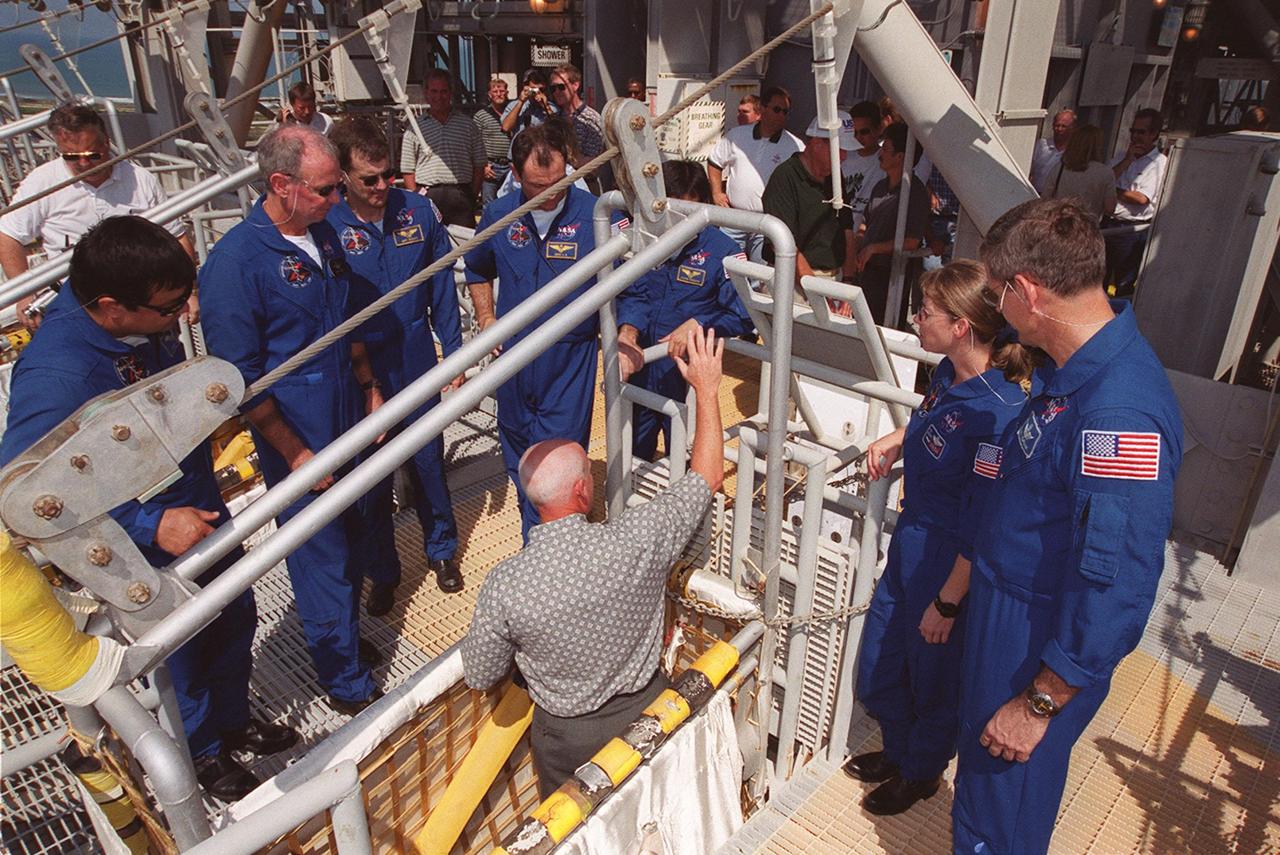 At the 195-foot level of the Fixed Service Structure on Launch Pad 39A, the STS-92 crew get instructions on using the slidewire baskets, part of emergency egress equipment. Gathered left to right are Mission Specialist Leroy Chiao; Commander Brian Duffy; Mission Specialists Peter J.K. “Jeff” Wisoff, Michael E. Lopez-Alegria and Koichi Wakata of Japan; Pilot Pamela Ann Melroy; and Mission Specialist William S. McArthur Jr. The crew is at KSC for Terminal Countdown Demonstration Test activities that also provide opportunities to inspect the mission payload and take part in a simulated countdown. STS-92 is scheduled to launch Oct. 5 at 9:38 p.m. EDT on the fifth flight to the International Space Station. It will carry two elements of the Space Station, the Integrated Truss Structure Z1 and the third Pressurized Mating Adapter. The mission is also the 100th flight in the Shuttle program