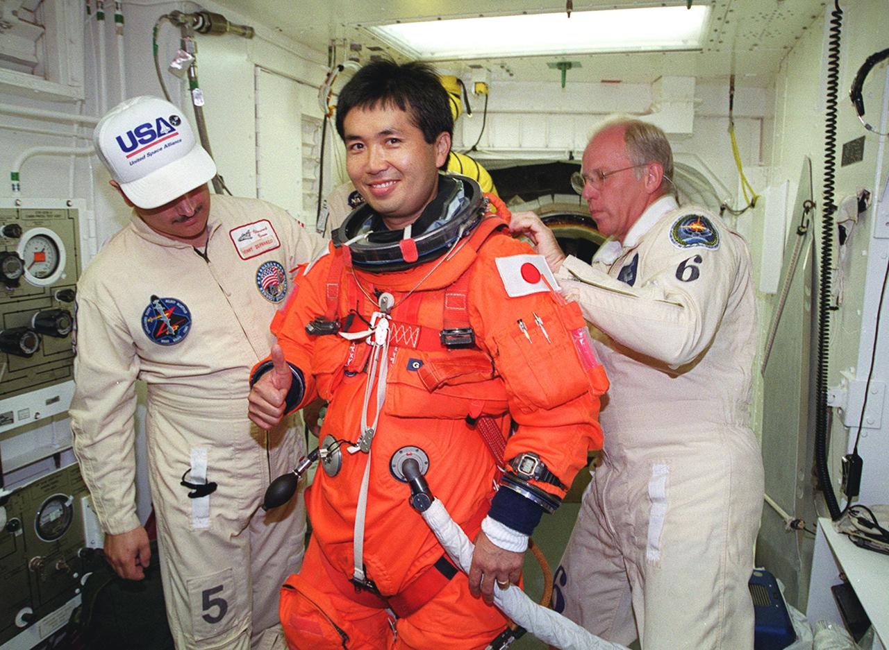 STS-92 Mission Specialist Koichi Wakata of Japan (center) gets help from United Space Alliance Mechanical Technician Vinny Difranzo (left) and NASA Quality Assurance Specialist Danny Wyatt (right) in suiting up in the White Room. Wakata and other crew members are taking part in a simulated countdown KSC for Terminal Countdown Demonstration Test (TCDT) activities. STS-92 is scheduled to launch Oct. 5 at 9:38 p.m. EDT on the fifth flight to the International Space Station. It will carry two elements of the Space Station, the Integrated Truss Structure Z1 and the third Pressurized Mating Adapter. The mission is also the 100th flight in the Shuttle program