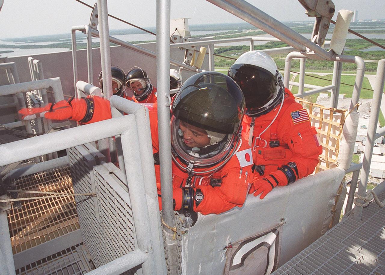 KENNEDY SPACE CENTER, FLA. -- STS-92 Mission Specialist Koichi Wakata of Japan reaches for a lever that will release the slidewire basket he is in. Behind him is Mission Specialist William S. McArthur Jr. In another basket (in the background) are Mission Specialists Leroy Chiao, Peter J.K. “Jeff” Wisoff and Michael E. Lopez-Alegria. They are taking part in emergency egress training, one of the Terminal Countdown Demonstration Test activities that also include a simulated countdown. STS-92 is scheduled to launch Oct. 5 at 9:38 p.m. EDT on the fifth flight to the International Space Station. It will carry two elements of the Space Station, the Integrated Truss Structure Z1 and the third Pressurized Mating Adapter. The mission is also the 100th flight in the Shuttle program