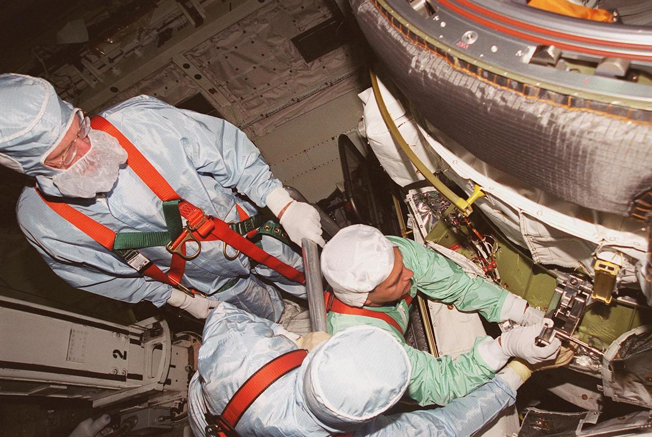 KENNEDY SPACE CENTER, FLA. -- In Orbiter Processing Facility (OPF) bay 2 during Crew Equipment Interface Test (CEIT), members of the STS-97 crew look over the Orbital Docking System (ODS) in Endeavour’s payload bay. At left, standing, is Mission Specialist Joe Tanner. At right is Mission Specialist Carlos Noriega, with his hands on the ODS. The others are workers in the OPF. The CEIT provides an opportunity for crew members to check equipment and facilities that will be on board the orbiter during their mission. The STS-97 mission will be the sixth construction flight to the International Space Station. The payload includes a photovoltaic (PV) module, providing solar power to the Station. STS-97 is scheduled to launch Nov. 30 from KSC for the 10-day mission