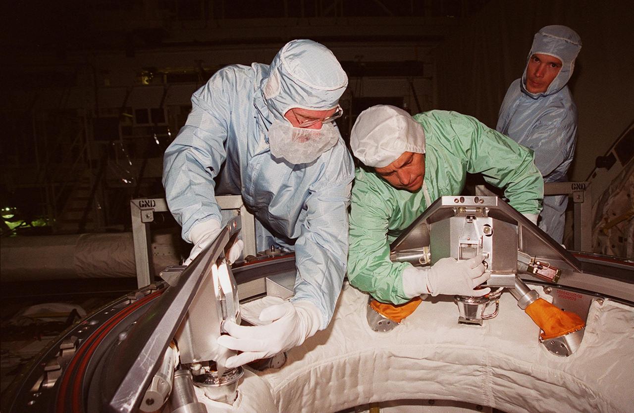 KENNEDY SPACE CENTER, FLA. -- In Orbiter Processing Facility (OPF) bay 2 during Crew Equipment Interface Test (CEIT), Mission Specialists Joe Tanner (left) and Carlos Noriega (right) practice working parts of the Orbital Docking System (ODS) in Endeavour’s payload bay. The CEIT provides an opportunity for crew members to check equipment and facilities that will be on board the orbiter during their mission. The STS-97 mission will be the sixth construction flight to the International Space Station. The payload includes a photovoltaic (PV) module, providing solar power to the Station. STS-97 is scheduled to launch Nov. 30 from KSC for the 10-day mission