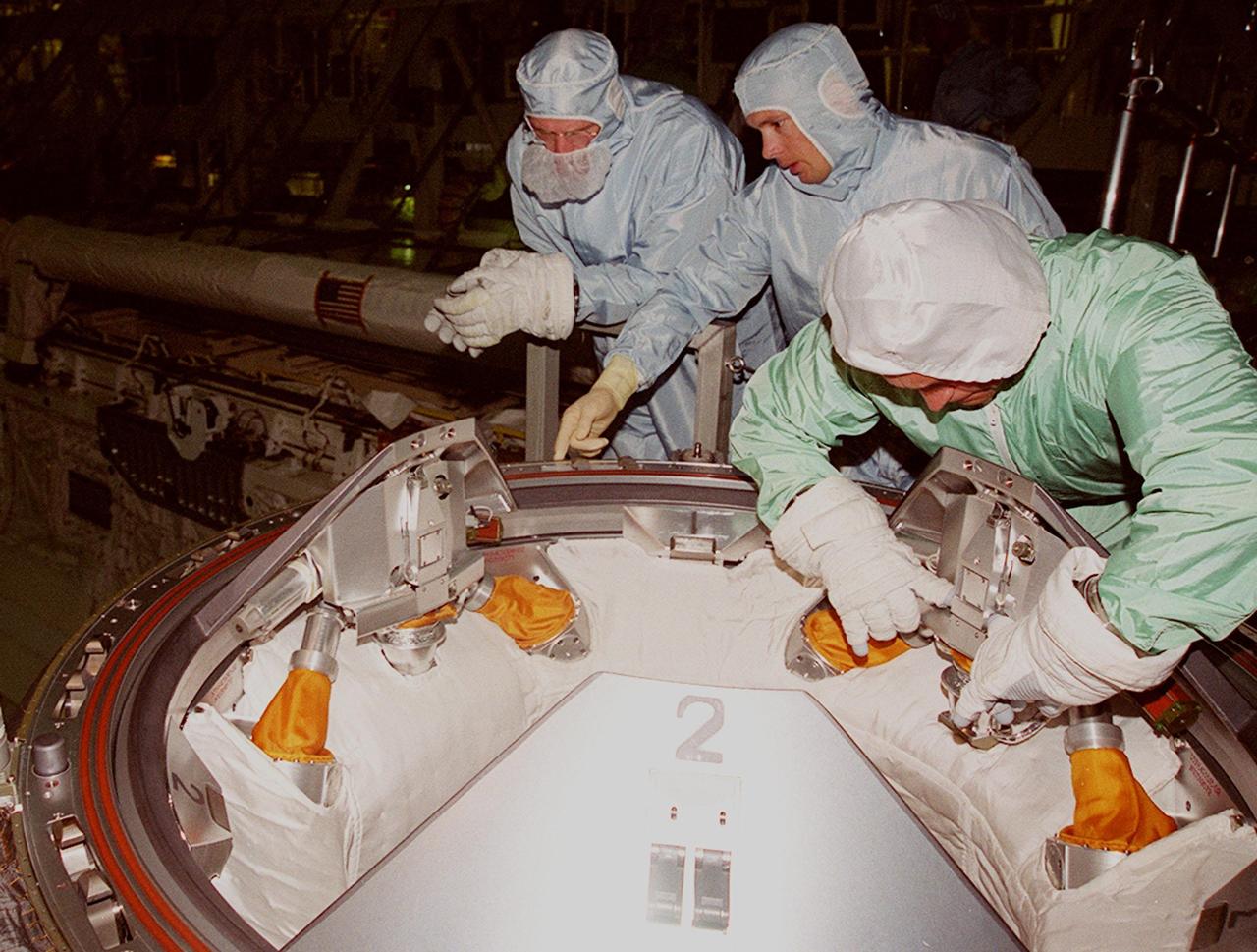 KENNEDY SPACE CENTER, FLA. -- In Orbiter Processing Facility (OPF) bay 2 during Crew Equipment Interface Test (CEIT), Mission Specialist Joe Tanner (left) gets instruction from a worker while Mission Specialist Carlos Noriega (right) practices working latches on the Orbital Docking System in Endeavour’s payload bay. The CEIT provides an opportunity for crew members to check equipment and facilities that will be on board the orbiter during their mission. The STS-97 mission will be the sixth construction flight to the International Space Station. The payload includes a photovoltaic (PV) module, providing solar power to the Station. STS-97 is scheduled to launch Nov. 30 from KSC for the 10-day mission
