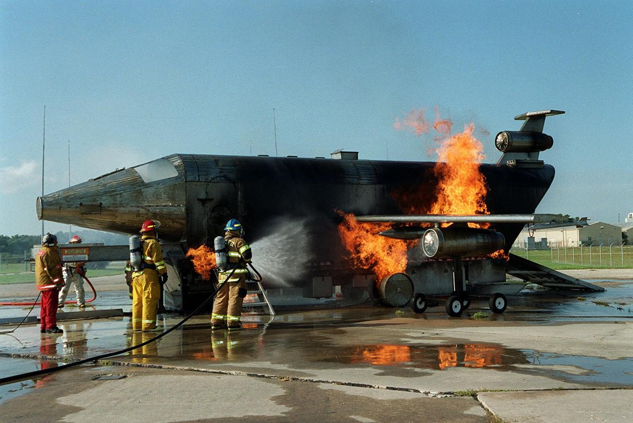 KENNEDY SPACE CENTER, FLA. -- During training exercises at Cape Canaveral Air Force Station Pad 30, firefighters with the Fire and Emergency Services at the Naval Station Mayport, Fla., turn their hoses toward the fire on the simulated aircraft.
