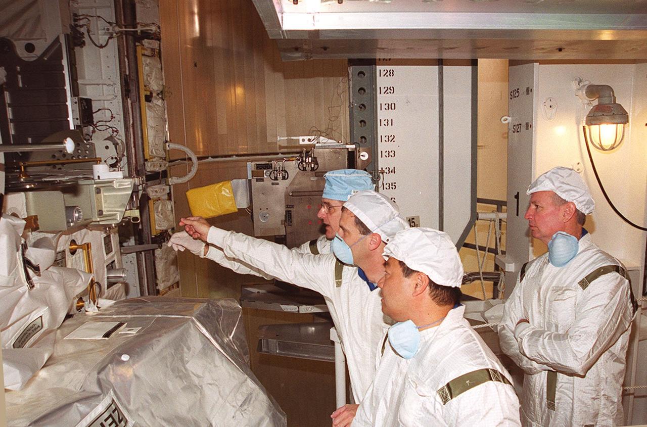 KENNEDY SPACE CENTER, FLA. -- Members of the STS-92 crew inspect part of the payload (left) in Space Shuttle Discovery’s payload bay. From left, they are Mission Specialists William S. McArthur Jr., Peter J.K. “Jeff” Wisoff and Leroy Chiao; Commander Brian Duffy is behind them. They and other crew members Pilot Pamela Ann Melroy and Mission Specialists Koichi Wakata of Japan and Michael E. Lopez-Alegria are preparing for launch on Oct. 5, 2000. The mission is the fifth flight for the construction of the International Space Station. The payload includes the Integrated Truss Structure Z-1 and the third Pressurized Mating Adapter. During the 11-day mission, four extravehicular activities (EVAs), or space walks, are planned