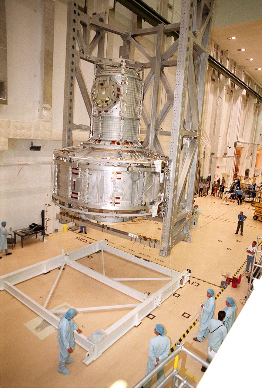 KENNEDY SPACE CENTER, FLA. -- In the Operations and Checkout Building, the Joint Airlock Module is lowered toward a stand on the floor where it will be moved to a horizontal position. Then it will be lifted into the payload canister for transfer to the Space Station Processing Facility. There it will continue to undergo preflight processing for the STS-104 mission scheduled for launch aboard Space Shuttle Atlantis May 17, 2001. The Joint Airlock Module is the gateway from which crew members aboard the International Space Station will enter and exit the 470-ton orbiting research facility