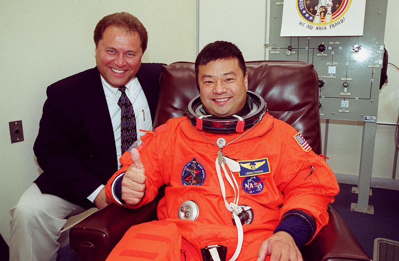 During suitup in the Operations and Checkout Building, STS-92 Mission Specialist Leroy Chiao gives thumbs up for launch. With him (left) is VITT Mission Lead Roland Nedelkovich, from Houston. During the 11-day mission to the International Space Station, four extravehicular activities (EVAs), or spacewalks, are planned for construction. The payload includes the Integrated Truss Structure Z-1 and the third Pressurized Mating Adapter. The Z-1 truss is the first of 10 that will become the backbone of the Space Station, eventually stretching the length of a football field. PMA-3 will provide a Shuttle docking port for solar array installation on the sixth Station flight and Lab installation on the seventh Station flight. Launch is scheduled for 7:17 p.m. EDT. Landing is expected Oct. 22 at 2:10 p.m. EDT