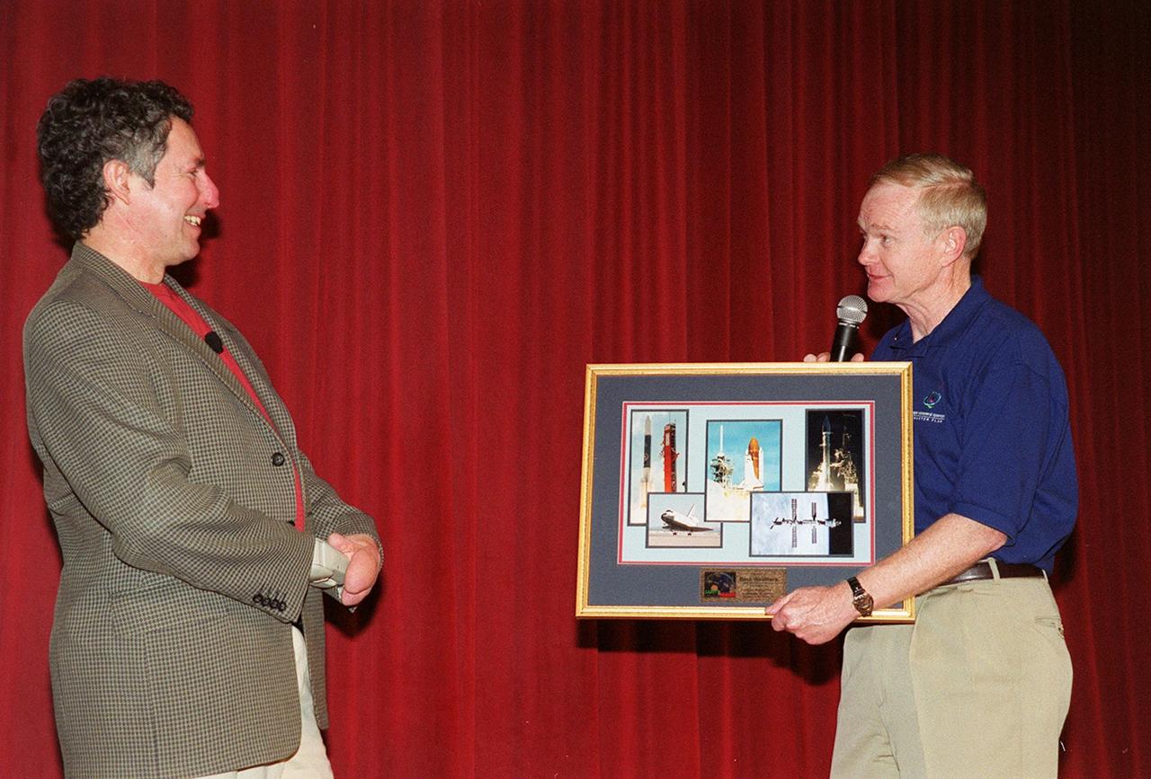 During Super Safety and Health Day at KSC, keynote speaker Dr. Beck Weathers is given a memento of his visit by Center Director Roy Bridges. Weathers spoke about his ordeal of surviving the 1996 Mt. Everest disaster and the lessons learned from the experience. Safety Day is a full day of NASA-sponsored, KSC and 45th Space Wing events involving a number of health and safety related activities: Displays, vendors, technical paper sessions, panel discussions, a keynote speaker, etc. The entire Center and Wing stand down to participate in the planned events. Safety Day is held annually to proactively increase awareness in safety and health among the government and contractor workforce population. The first guiding principle at KSC is “Safety and Health First.” KSC’s number one goal is to “Assure sound, safe and efficient practices and processes are in place for privatized/commercialized launch site processing.