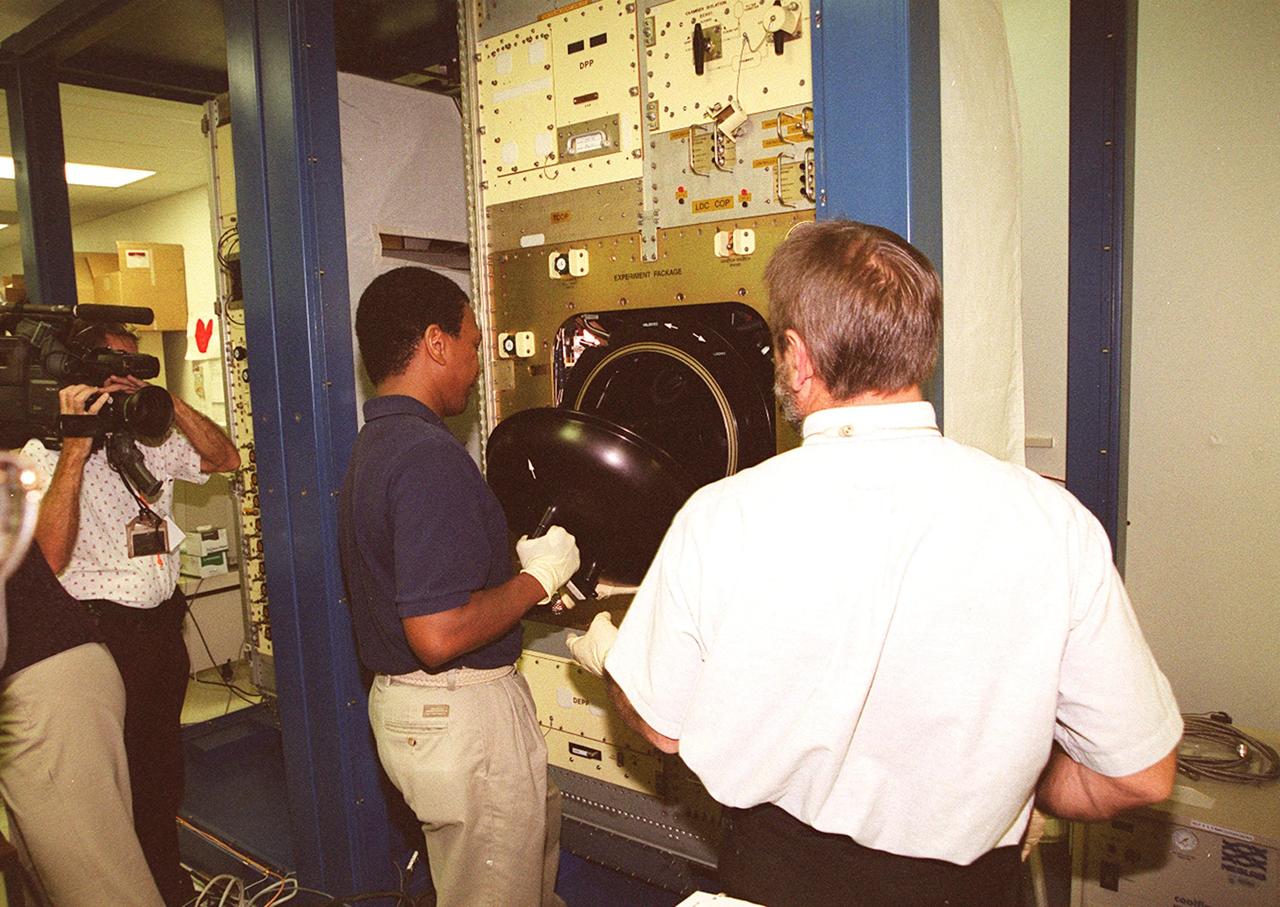 KENNEDY SPACE CENTER, FLA. -- At SPACEHAB, STS-107 Mission Specialist Michael Anderson (gloved, in center) gets hands-on experience with equipment. Identified as a research mission, STS-107 is scheduled for launch July 19, 2001