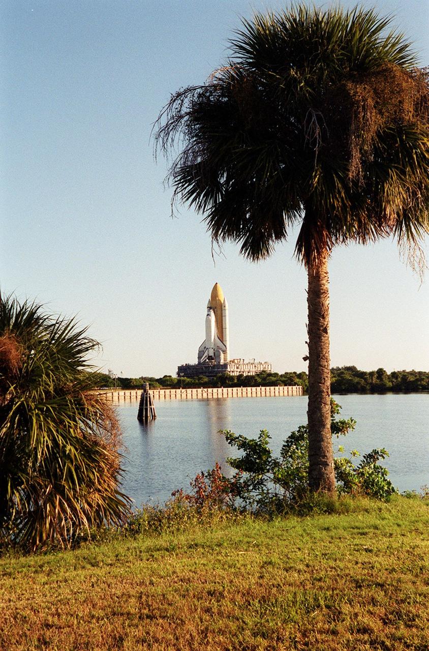 KENNEDY SPACE CENTER, Fla. -- Space Shuttle Endeavour appears to be framed by palms in this view across the turn basin at KSC. Endeavour is inching its way to Launch Pad 39B via the crawlerway that leads from the Vehicle Assembly Building. The Shuttle is on the Mobile Launcher Platform (MLP) which is atop the crawler-transporter, moving on four double-tracked crawlers. The maximum speed of the loaded transporter is 1 mph. Endeavour is scheduled to be launched Nov. 30 at 10:01 p.m. EST on mission STS-97, the sixth construction flight to the International Space Station. Its payload includes the P6 Integrated Truss Structure and a photovoltaic (PV) module, with giant solar arrays that will provide power to the Station. The mission includes two spacewalks to complete the solar array connections