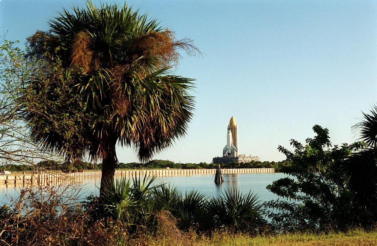 KENNEDY SPACE CENTER, Fla. -- Viewed from across the turn basin at KSC, Space Shuttle Endeavour inches its way to Launch Pad 39B via the crawlerway that leads from the Vehicle Assembly Building. The Shuttle is on the Mobile Launcher Platform (MLP) which is atop the crawler-transporter, moving on four double-tracked crawlers. The maximum speed of the loaded transporter is 1 mph. Endeavour is scheduled to be launched Nov. 30 at 10:01 p.m. EST on mission STS-97, the sixth construction flight to the International Space Station. Its payload includes the P6 Integrated Truss Structure and a photovoltaic (PV) module, with giant solar arrays that will provide power to the Station. The mission includes two spacewalks to complete the solar array connections