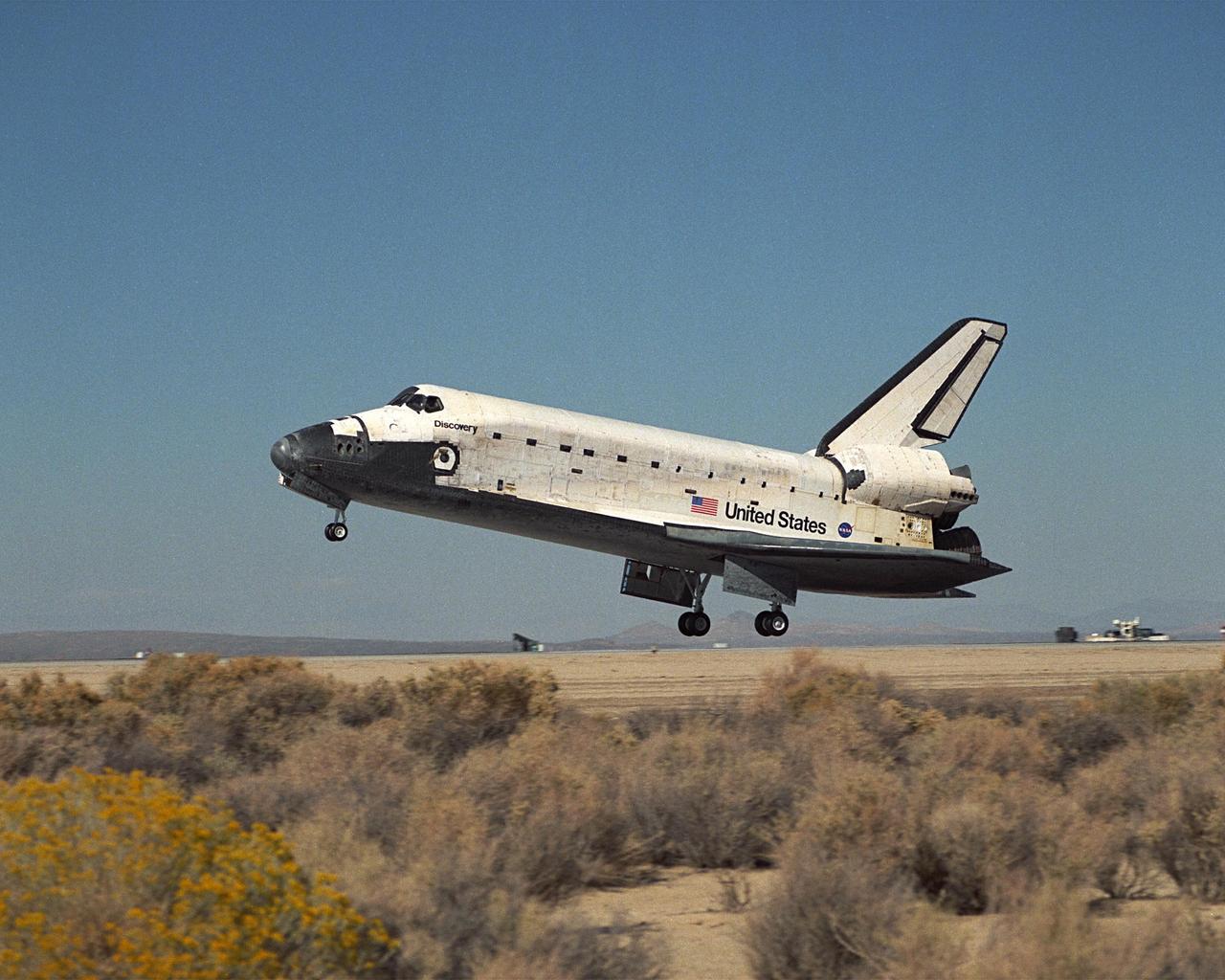 Viewed from the side, orbiter Discovery, with its seven-member crew, is about to touch down on the landing strip at Edwards Air Force Base, Calif., after an 11-day mission to the International Space Station. The orbiter’s main landing gear touched down on EAFB runway 22 at 5 p.m. With the aid of its drag chute, Discovery came to a complete stop at 5:01 p.m. At the conclusion of mission STS-92, Discovery and crew had traveled about 5.3 million statute miles. Following vehicle safing and preliminary offloading efforts, workers will begin preparations for Discovery’s transcontinental ferry flight back to KSC on the back of NASA’s modified Boeing 747