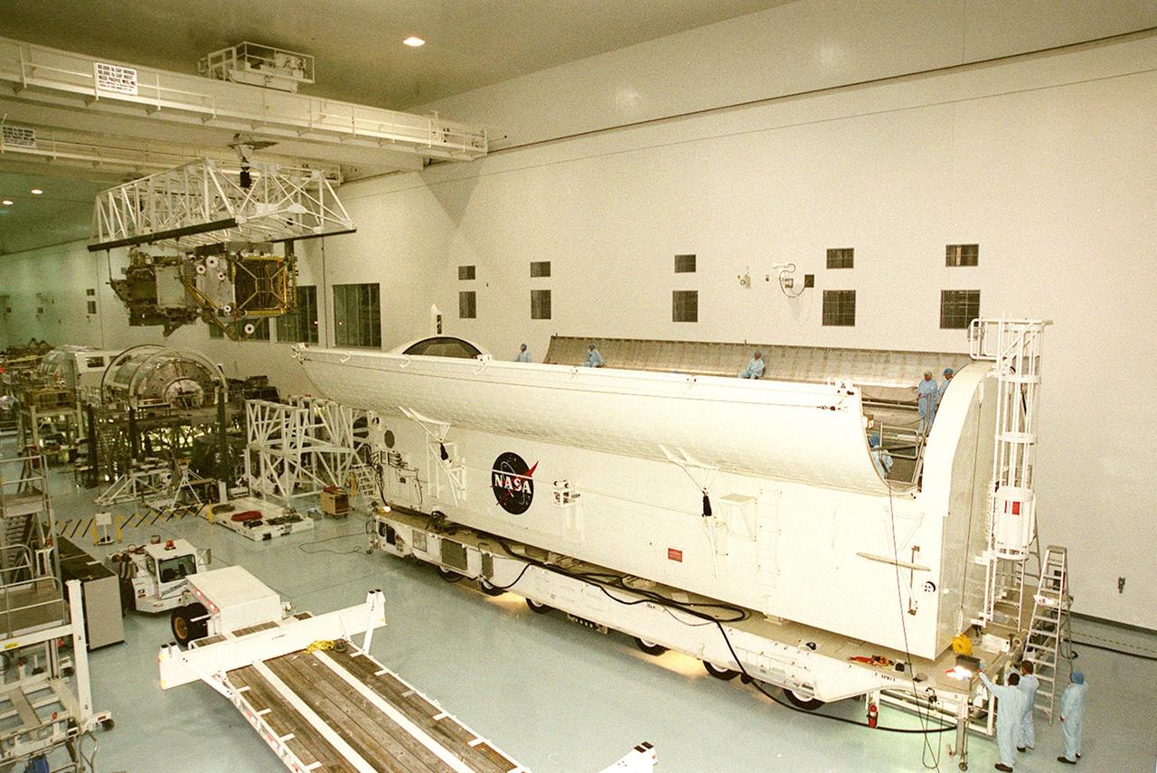 KENNEDY SPACE CENTER, FLA. -- The payload transport canister (right) and workers wait for the arrival of the P6 integrated truss segment (left) carried by the overhead crane. After being placed in the canister, the truss will be transported to Launch Pad 39B and the payload changeout room. Then it will be moved into Space Shuttle Endeavour’s payload bay for mission STS-97. The P6 comprises Solar Array Wing-3 and the Integrated Electronic Assembly, to be installed on the Space Station. The Station’s electrical power system will use eight photovoltaic solar arrays, each 112 feet long by 39 feet wide, to convert sunlight to electricity. The solar arrays are mounted on a “blanket” that can be folded like an accordion for delivery. Once in orbit, astronauts will deploy the blankets to their full size. Gimbals will be used to rotate the arrays so that they will face the Sun to provide maximum power to the Space Station. The STS-97 launch is scheduled Nov. 30 at 10:06 p.m. EST