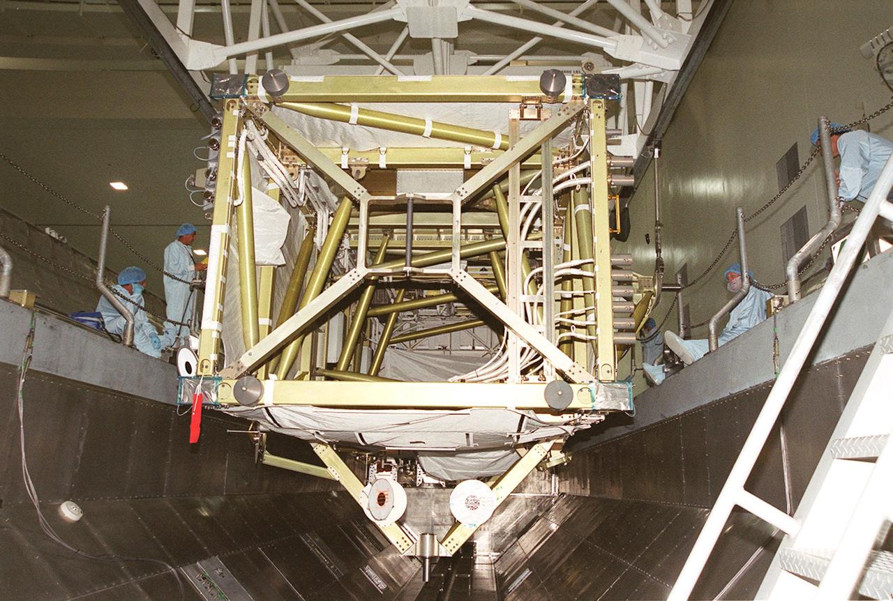 KENNEDY SPACE CENTER, FLA. -- In the Space Station Processing Facility, the P6 integrated truss segment is placed in the payload transport canister while workers watch its progress. After being secured in the canister, the truss will be transported to Launch Pad 39B and the payload changeout room. Then it will be moved into Space Shuttle Endeavour’s payload bay for mission STS-97. The P6 comprises Solar Array Wing-3 and the Integrated Electronic Assembly, to be installed on the Space Station. The Station’s electrical power system will use eight photovoltaic solar arrays, each 112 feet long by 39 feet wide, to convert sunlight to electricity. The solar arrays are mounted on a “blanket” that can be folded like an accordion for delivery. Once in orbit, astronauts will deploy the blankets to their full size. Gimbals will be used to rotate the arrays so that they will face the Sun to provide maximum power to the Space Station. The STS-97 launch is scheduled Nov. 30 at 10:06 p.m. EST
