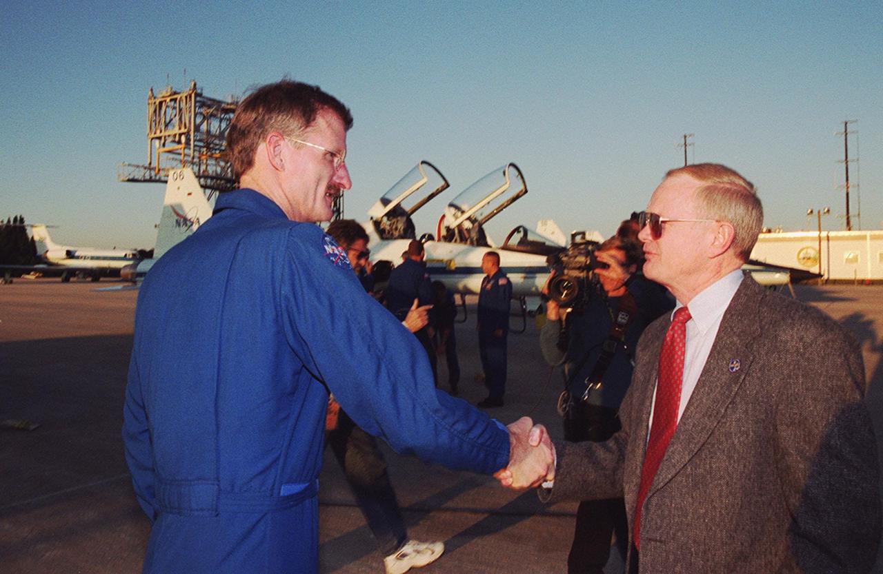 At the Shuttle Landing Facility, STS-97 Mission Specialist Joseph Tanner (left) is greeted by Center Director Roy Bridges on his arrival at KSC from Johnson Space Center. Tanner and the rest of the crew have returned to KSC for the launch, scheduled for Nov. 30 at about 10:06 p.m. EST. Mission STS-97is the sixth construction flight to the International Space Station. Its payload includes the P6 Integrated Truss Structure and a photovoltaic (PV) module, with giant solar arrays that will provide power to the Station. The mission includes two spacewalks to complete the solar array connections. STS-97 is scheduled to launch Nov. 30 at about 10:06 p.m. EST