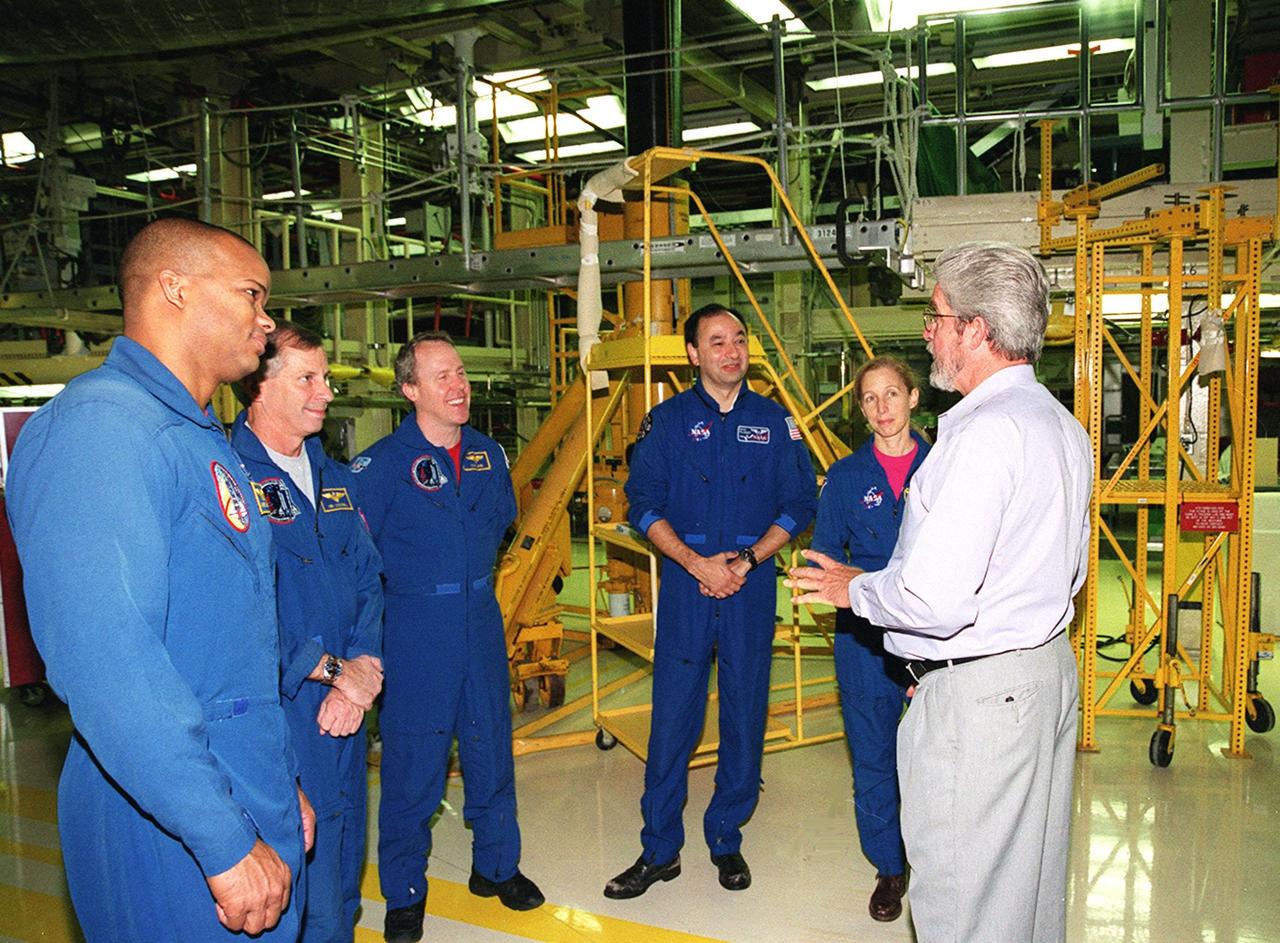 KENNEDY SPACE CENTER, FLA. -- In Orbiter Processing Facility bay 3, the STS-98 crew talks with United Space Alliance worker Larry Oshein (right). Standing left to right are Mission Specialist Robert Curbeam, Commander Ken Cockrell, Mission Specialist Tom Jones, and Mission Specialists Mark Polansky and Marsha Ivins. The crew is at KSC for Crew Equipment Interface Test activities. Launch on mission STS-98 is scheduled for Jan. 18, 2001. It will be transporting the U.S. Lab, Destiny, to the International Space Station with five system racks already installed inside of the module. After delivery of electronics in the lab, electrically powered attitude control for Control Moment Gyroscopes will be activated