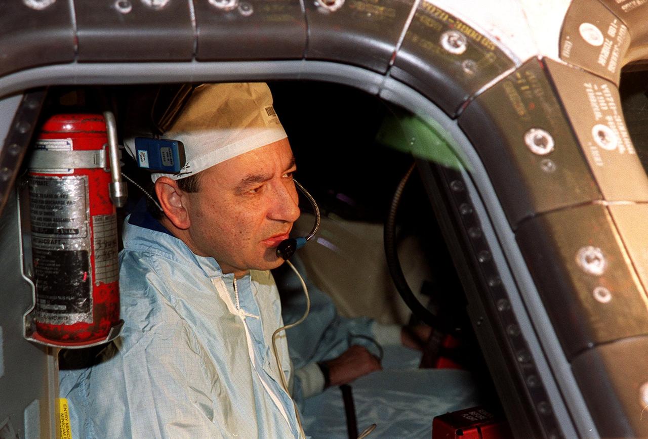 KENNEDY SPACE CENTER, FLA. -- In Orbiter Processing Facility bay 3, STS-98 Pilot Mark Polansky inspects the window in the cockpit of Atlantis. He and the rest of the crew are at KSC for Crew Equipment Interface Test activities. Launch on mission STS-98 is scheduled for Jan. 18, 2001. It will be transporting the U.S. Lab, Destiny, to the International Space Station with five system racks already installed inside of the module. After delivery of electronics in the lab, electrically powered attitude control for Control Moment Gyroscopes will be activated