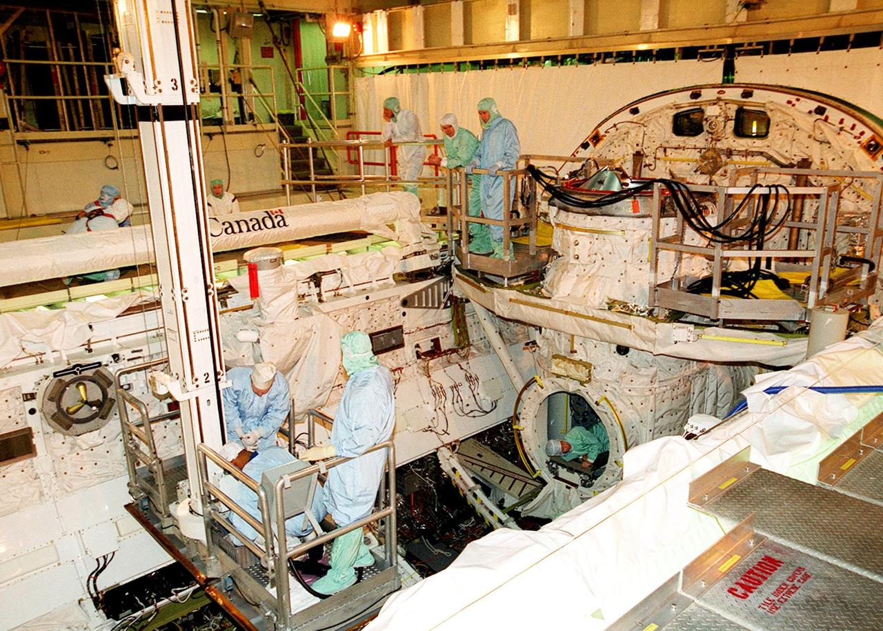 KENNEDY SPACE CENTER, FLA. -- The STS-98 crew looks over components of the equipment already installed in the payload bay of orbiter Atlantis, which is in the Orbiter Processing Facility bay 3. The crew is at KSC for Crew Equipment Interface Test activities. Launch on mission STS-98 is scheduled for Jan. 18, 2001. It will be transporting the U.S. Lab, Destiny, to the International Space Station with five system racks already installed inside of the module. After delivery of electronics in the lab, electrically powered attitude control for Control Moment Gyroscopes will be activated