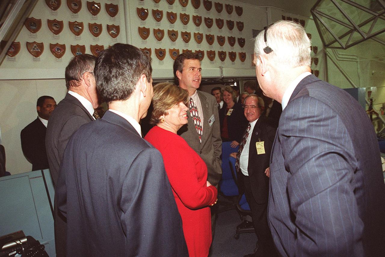 KENNEDY SPACE CENTER, FLA. -- In the Firing Room, Launch Control Center, after a successful launch of STS-97, VIPs gather to congratulate the launch team. In the center of the photo is Florida Governor Jeb Bush. On his left is KSC Director of External Relations and Business Development JoAnn H. Morgan; on Bush’s right is Joseph Rothenberg, associate administrator, Office of Space Flight; on the far right is Bill Readdy, manager at Johnson Space Center. Liftoff of Endeavour occurred at 10:06:01 p.m. EST. Endeavour and its five-member crew will deliver U.S. solar arrays to the International Space Station and be the first Shuttle crew to visit the Station’s first resident crew. The 11-day mission includes three spacewalks. This marks the 101st mission in Space Shuttle history and the 25th night launch. Endeavour is expected to land at KSC Dec. 11 at 6:19 p.m. EST