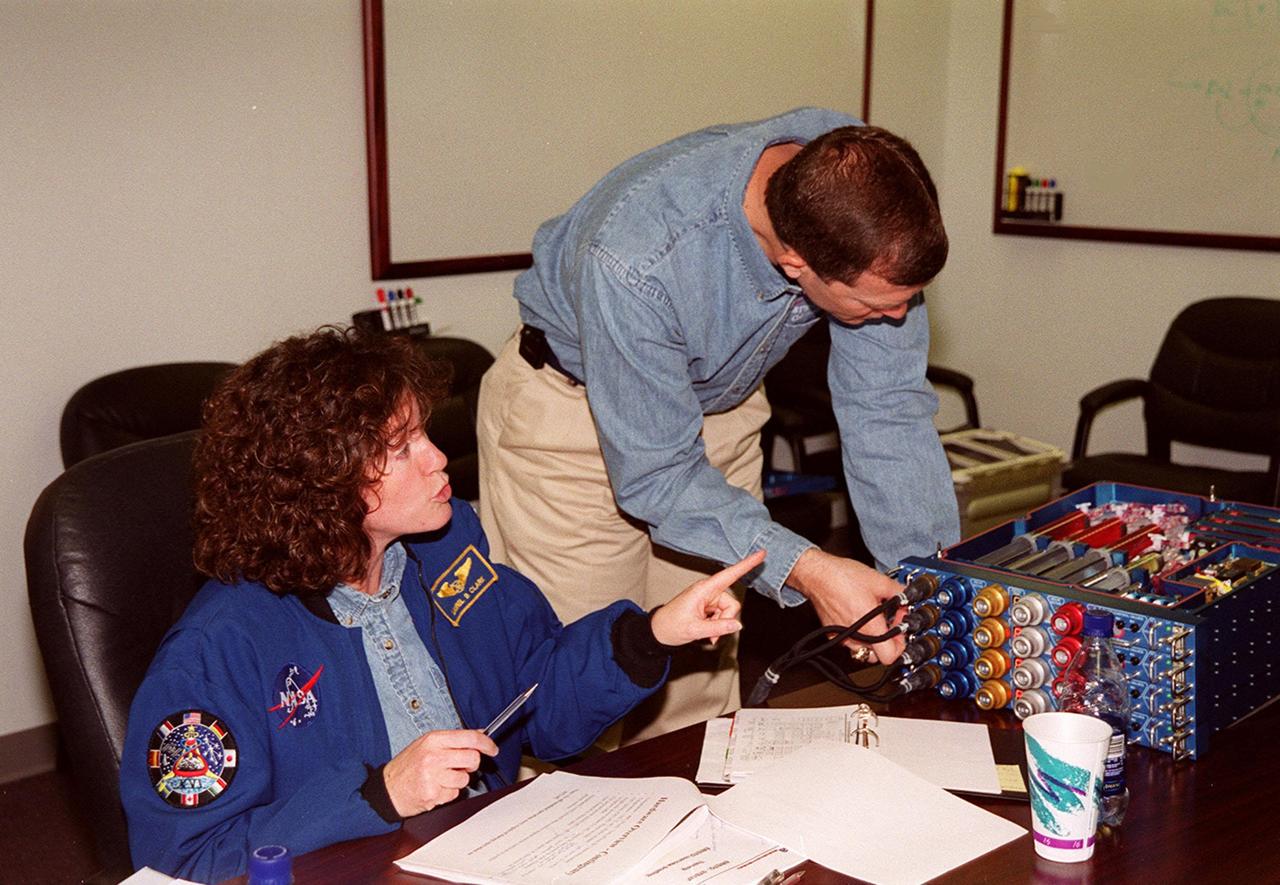 KENNEDY SPACE CENTER, FLA. -- Members of the STS-107 crew take part in In-Flight Maintenance training for their mission. Looking over an OSTEO experiment are Mission Specialist Laurel Clark (left) and Commander Rick d. Husband. As a research mission, STS-107 will carry the SPACEHAB Double Module in its first research flight into space and a broad collection of experiments ranging from material science to life science. It is scheduled to launch July 19, 2001