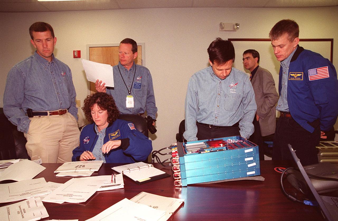 KENNEDY SPACE CENTER, FLA. -- Members of the STS-107 crew take part in In-Flight Maintenance training for their mission. Looking over an OSTEO experiment and paperwork are (left to right) Commander Rick D. Husband; Mission Specialists Laurel Clark, David M. Brown and Ilan Ramon of Israel; and Pilot William C. “Willie” McCool. As a research mission, STS-107will carry the SPACEHAB Double Module in its first research flight into space and a broad collection of experiments ranging from material science to life science. It is scheduled to launch July 19, 2001