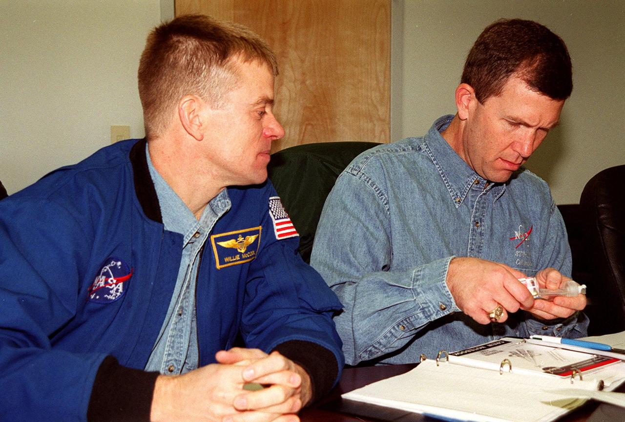 KENNEDY SPACE CENTER, FLA. -- STS-107 Pilot William C. “Willie” McCool (left) and Commander Rick D. Husband look over equipment for their mission. They and other crew members are taking part in In-Flight Maintenance training. Research mission STS-107, scheduled to launch July 19, 2001, will carry the SPACEHAB Double Module in its first research flight into space and a broad collection of experiments ranging from material science to life science