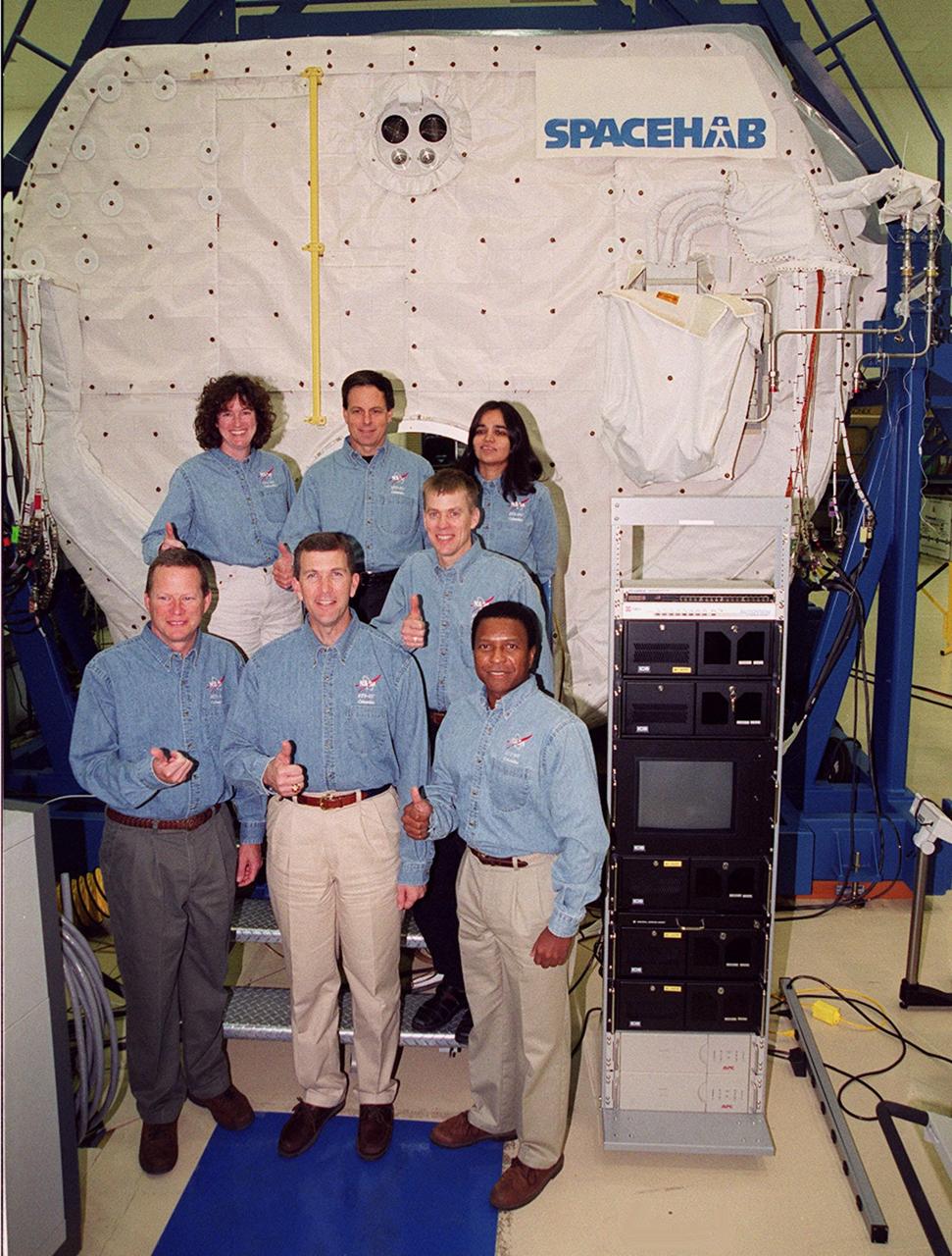 KENNEDY SPACE CENTER, Fla. -- Taking part in In-Flight Maintenance training, the STS-107 crew poses in front of the SPACEHAB Double Module. In back are Mission Specialist Laurel Clark, Payload Specialist Ilan Ramon of Israel and Mission Specialist Kalpana Chawla; in front are Mission Specialist David M. Brown, Commander Rick D. Husband, Pilot William C. “Willie” McCool (behind) and Mission Specialist Michael Anderson. As a research mission, STS-107 will carry the SPACEHAB Double Module in its first research flight into space and a broad collection of experiments ranging from material science to life science. It is scheduled to launch July 19, 2001