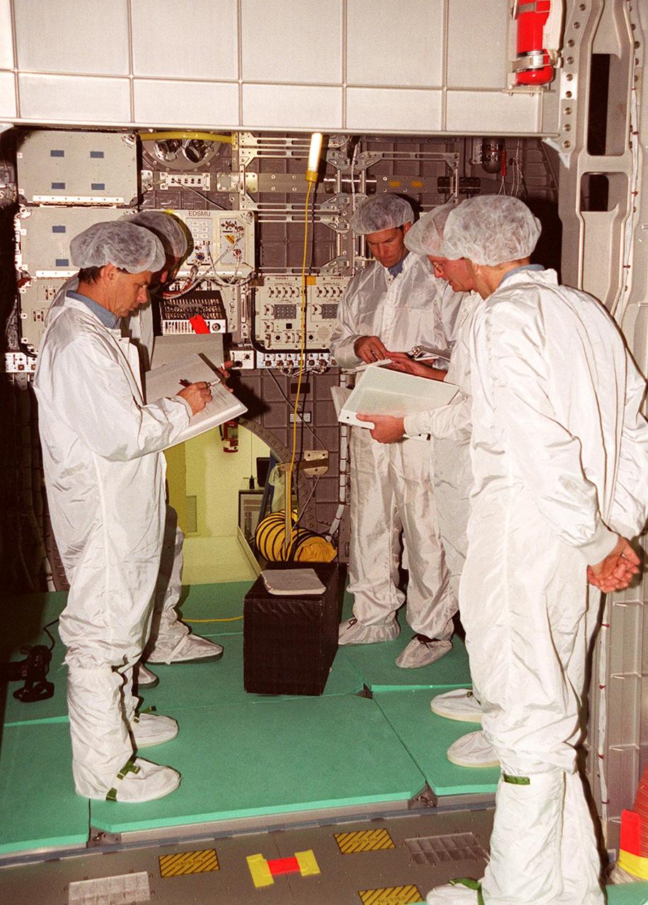 KENNEDY SPACE CENTER, Fla. -- Members of the STS-107 crew look over equipment inside the SPACEHAB Double Module, which will be making its first research flight into space on STS-107. Seen are (left to right) Payload Specialist Ilan Ramon and Mission Specialist David M. Brown, Commander Rick D. Husband, [trainer David Butler] and Pilot William C. “Willie” McCool. STS-107 will carry a broad collection of experiments ranging from material science to life science. It is scheduled to launch July 19, 2001