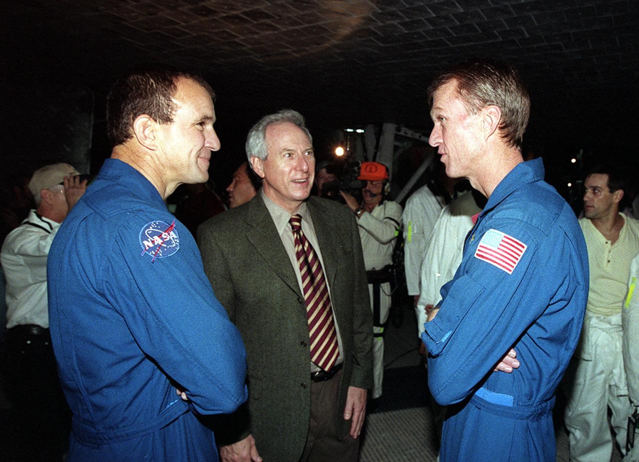 KENNEDY SPACE CENTER, FLA. -- Shortly after the landing of Endeavour, NASA Administrator Daniel Goldin (center) talks with STS-97 Pilot Michael Bloomfield (left) and Commander Brent Jett (right) underneath the orbiter. Landing occurred at 6:04 p.m. EST. On the 4.4-million-mile mission, Endeavour carried the P6 Integrated Truss Structure with solar arrays to power the International Space Station. The arrays and other equipment were installed during three EVAs that totaled 19 hours, 20 minutes. Endeavour was docked with the Space Station for 6 days, 23 hours, 13 minutes. This is the 16th nighttime landing for a Space Shuttle and the 53rd at Kennedy Space Center