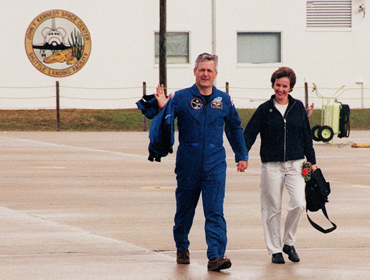 KENNEDY SPACE CENTER, FLA. -- After a night’s rest and a brief press conference at KSC, STS-97 Mission Specialist Marc Garneau heads for a plane at the Shuttle Landing Facility. With him is his wife. They and other crew members and their families are returning to Houston. Garneau is with the Canadian Space Agency.Mission STS-97 ended on Dec. 11, 2000, with a landing at KSC at 6:04 p.m. EST
