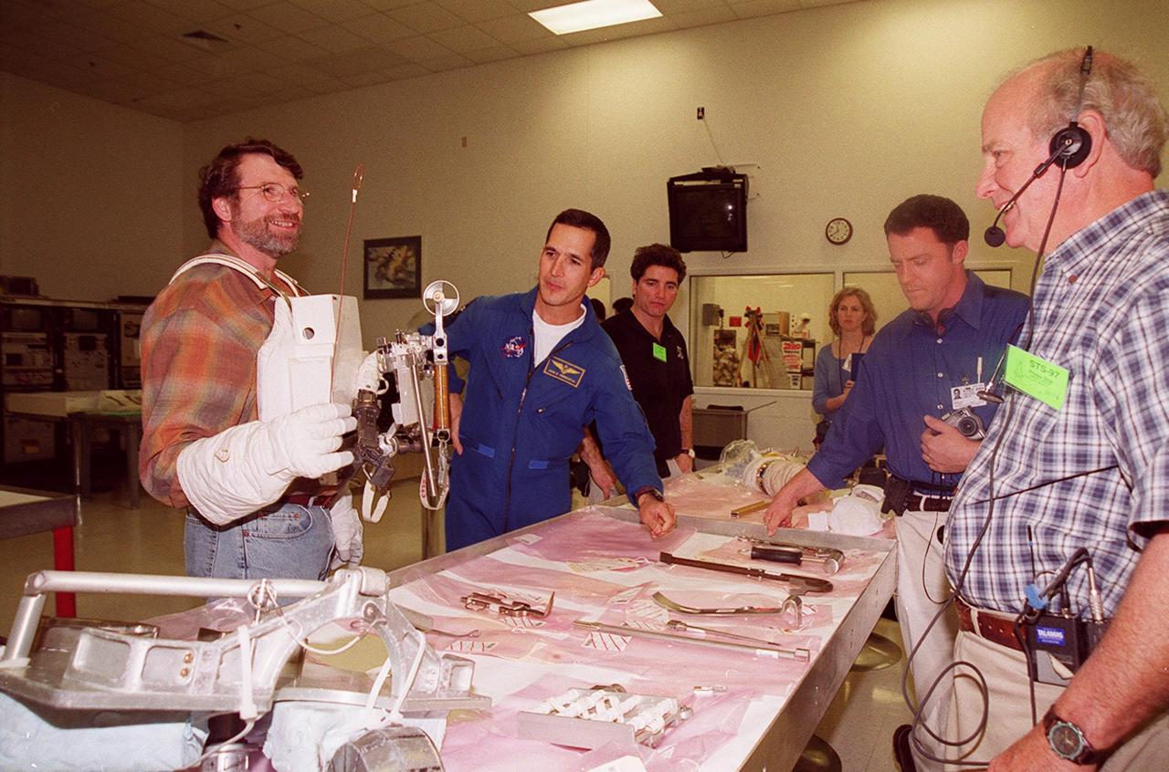 KENNEDY SPACE CENTER, FLA. --  Norm Abram, of television’s "This Old House" and "The New Yankee Workshop," looks at tools and equipment used in space while astronaut John Herrington (second from left) watches. At right are two of the film crew with Abram. Abram is at KSC to film an episode of "This Old House.